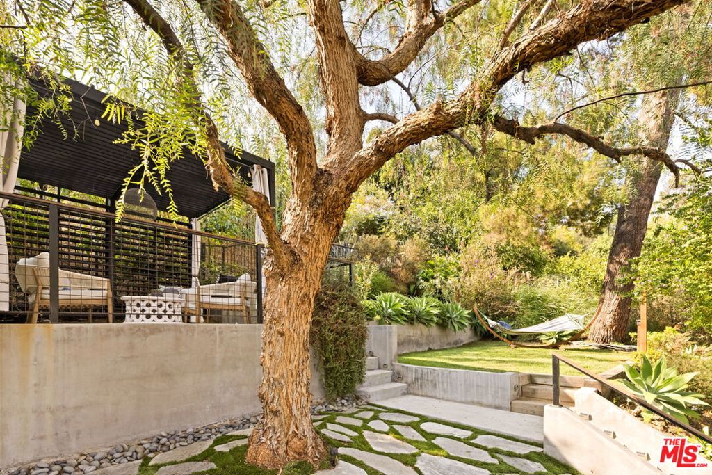 Tucked away behind mature hedges, in the heart of Highland Park, 1057 Milwaukee is a masterclass in reinvention. A 1921 classic, meticulously reimagined in 2018 and transformed into a warm, architectural modern that honors the neighborhood's heritage while embracing elevated, contemporary living. Inside, sunlight fills a beautiful, open layout where clean lines meet organic finishes. The chef's kitchen anchors the space with custom cabinetry, high-end appliances, and a minimalist aesthetic that whispers luxury. Vaulted ceilings and skylights add volume and light, while wide-plank floors flow effortlessly through the three serene bedrooms and two sleek bathrooms. Outside you'll find a thoughtfully landscaped backyard, an enchanting gardenyour private retreat for entertaining, gardening, or slow mornings basking in the sun. The yard's upper level creates a romantic dining or lounging area with views of the hills and colorful butterflies. The garage offers additional storage space or the potential to create an amazing office, gym or even an ADU (buyer to verify). This unique property is located just moments from the buzz of York Blvd. and Figueroa Street and blends created design with access to some of LA's best coffee, restaurants, hip shops, and creative culture. Whether you're a design lover, an Eastside enthusiast, or simply looking for a turnkey escape in one of LA's most sought-after neighborhoodsthis is the one.