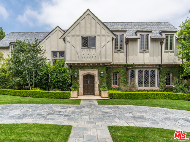 Nestled within the exclusive Beverly Hills flats, on more than ½ an acre, sits this gorgeous country English-style estate. Behind hedges and gates, a large semi-circular driveway is crowned by the home's stately, vine-covered facade punctuated by period leaded windows. Originally built in the 1920s, no detail has been spared in the restoration retaining the style and finishes of the period while completing extensive renovations to enhance with modern luxuries throughout. Traditional interiors include both formal and informal living and dining spaces, chef's kitchen with La Cornue range, 5 generous en-suite guest rooms upstairs, plus a staggering master suite. Outdoor areas welcome open-air entertainment and relaxation on a dining patio, manicured grounds and lawns and large pool terrace protected by walls of mature trees for ultimate privacy. Amenities such as a 2-story guesthouse, billiards room with wet bar, sport court, and wine cellar complete this magnificent Beverly Hills estate.