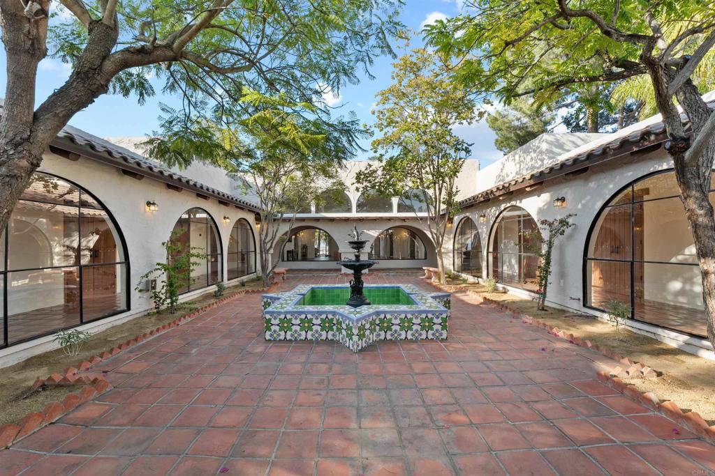 Truly one of the most unique and authentic properties on the market—this custom-built Mexican Hacienda replica was crafted using materials, windows, and finishes imported directly from Mexico to capture timeless architecture and traditional charm. Set on 2.51 usable acres, this 5,792 sq ft estate offers 5 bedrooms, 3.5 bathrooms, a formal library, and a state-of-the-art kitchen with panel-ready appliances and artisan cabinetry. The design features soaring ceilings, arched passageways throughout, and dozens of oversized iron-framed arched windows—many over 12 feet tall—filling the home with natural light and creating a dramatic yet elegant aesthetic. Enjoy seamless indoor-outdoor living with an infinity-edge pool, covered patios, and panoramic views. The property also features a 6-car garage, children’s play area, animal-ready corrals, and ample space for fruit trees, herb gardens, and vegetable cultivation—perfect for a sustainable lifestyle. Located in a peaceful, private setting, this is a rare opportunity to own a legacy estate with character, craftsmanship, and long-term potential.