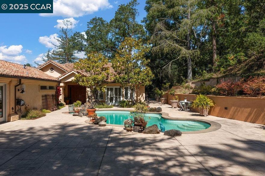 Welcome to your own private oasis, tucked behind a secure gate on a serene 1.32-acre hillside parcel.This extraordinary estate blends elegant architecture, thoughtful design, and breathtaking natural surroundings to create a resort-style retreat you’ll call home. A concrete driveway guides you past lush surroundings to an upper patio and expansive outdoor entertaining space.The main level features an open-concept great room with soaring ceilings and walls of windows that showcase breathtaking hillside views. One of the two resort-style primary suites is conveniently located on the first floor, perfect for in-law and guests.The chef’s kitchen boasts a dramatic design with an oversized granite island, high-end appliances and abundant counter space. The lower level features two additional primary suites, along with a generously sized bonus room that serves as a flexible recreation space. Multiple decks surround the home and are accessible from nearly every interior room, offering seamless indoor-outdoor living. A beautifully landscaped backyard with towering trees that provide shade on warm summer days, a built-in BBQ, and a sparkling pool and spa—perfect for entertaining. This home is the epitome of relaxed luxury, where comfort, style, and privacy come together in perfect harmony.