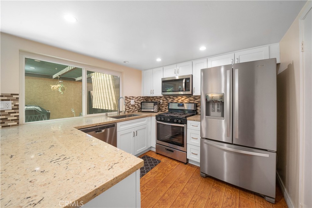 LOTS OF UPDATES!! Beautiful 2bed 2.5bath Winnetka townhome in gorgeous, gated Franciscan Park community SHOWS BETTER THAN THE PHOTOS!! Two story townhome with no one above or below! Kitchen remodeled in 2022 features quartz counters, white shaker cabinets, tile backsplash and all kitchen appliances replaced to new that year. Half bath located downstairs. Both bedrooms upstairs have en-suite bathrooms and ample closet space!! Primary suite bathroom was remodeled in 2022 with beautiful tiled shower. Primary suite closet has builtins for more efficient closet storage. Your own private 2 car garage with direct access to your large shaded patio. ELECTRICAL PANEL REPLACED 2022! NEW HVAC installed 2023! NEW WINDOWS installed 2021. WOOD FLOORING installed 2019. WATER HEATER replaced 2021. This super cute little neighborhood is like an oasis in the desert with park like grounds, sparkling community pool, lots of guest parking and it’s located right in the center of town! Quick drive to 101 and 118 freeways. Park across the street has tennis courts and children's playground. Easy access to Malibu Beaches, and nearby shopping in Woodland Hills / Ventura Blvd.