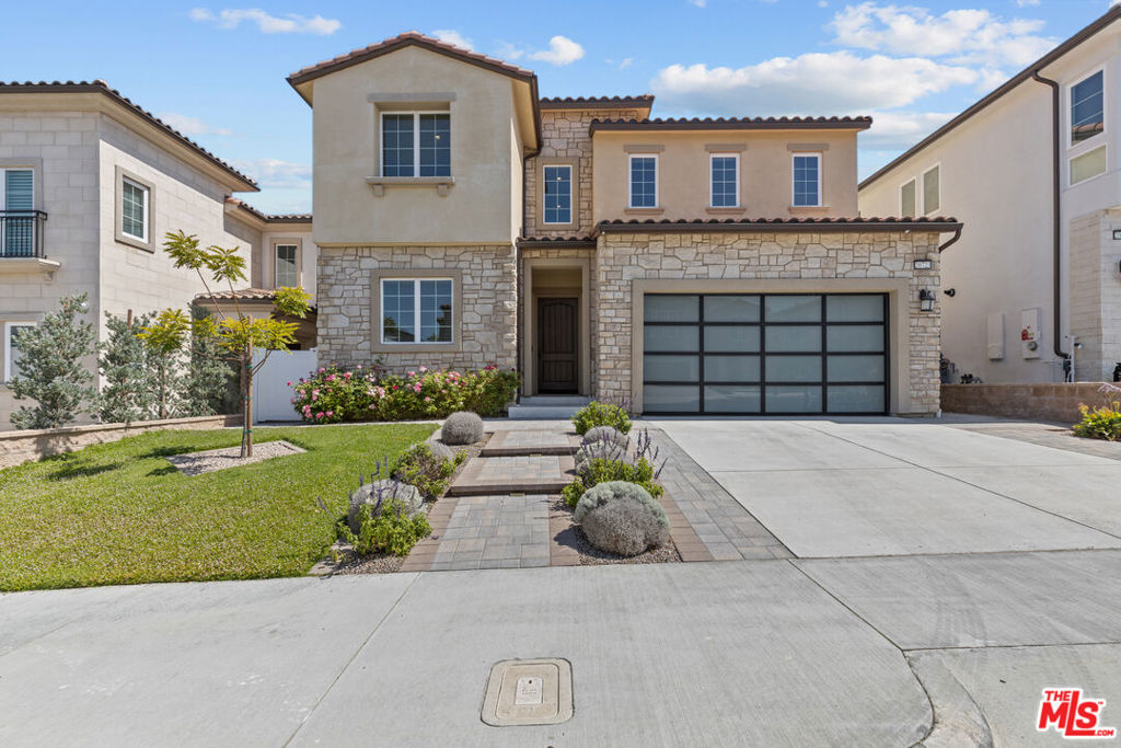 Welcome to the luxurious guard-gated community of Hillcrest at Porter Ranch. This stunning five-bedroom, six-bathroom home boasts 3,880 square feet and is equipped with solar panels paid for by the owner and an EV charger in the garage. The ground level features beautiful wood flooring throughout. The first level features a living room, a downstairs bedroom suite with its private entrance, a powder room, an additional flex bedroom (beyond the already five bedrooms), and a gorgeous kitchen that opens up to the family room. The modern kitchen is a chef's dream with plenty of cabinets, a walk-in pantry, a refrigerator, a microwave oven, and a 6-burner stove. A breakfast island is also ideal for preparing meals, and a dining area is conveniently located adjacent to the kitchen. On the second level, you will find a loft, a primary en-suite with a custom walk-in closet, and a spa-like bathtub, undoubtedly a highlight, offering the utmost relaxation with its stand-alone tub and dual shower. There are three additional bedrooms upstairs and a laundry room that provides both a washer and a dryer. Sliding doors lead to a covered patio and a low-maintenance yard, beautifully landscaped, perfect for those summer nights. You'll also enjoy easy access to the new Vineyards shopping, dining, a movie theater, banks, medical offices, award-winning schools, hiking trails, and the freeway.