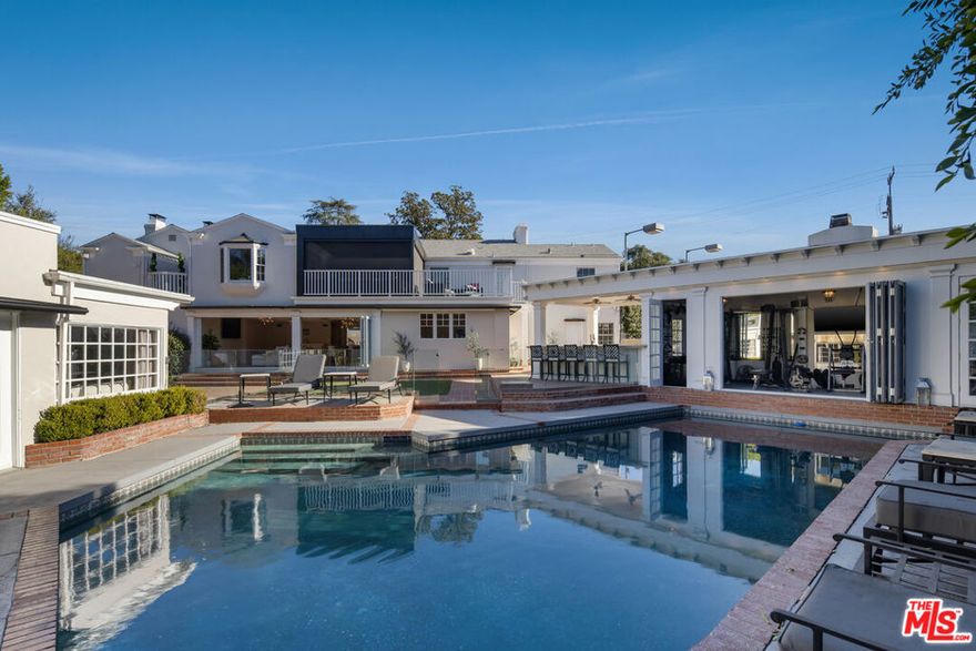 Hidden behind towering privacy hedges, the crown jewel of Encino's "Rancho Estates" quietly reveals itself a true family sanctuary where luxury meets livability. Long regarded as one of the Valley's premiere neighborhoods, this estate enjoys an ideal location that offers quick access to wherever life takes you yet it's so complete, so thoughtfully designed, that you'll never want to leave. The ultimate in privacy and security, this Tennis Court estate offers a bevy of luxury amenities. It's a warm and welcoming backdrop for family life.The property embodies the best of California living: total privacy, elegant design, and endless opportunities for fun, fitness, and connection. You'll appreciate the sophisticated styling and on-trend design finishes. You'll love the expansive, renovated kitchen with its modern open-concept flow it's a natural gathering spot for cooking, conversation, and connection. The dual staircases create a comfortable feel for this elegant estate. The secondary bedrooms are conveniently located adjacent to a truly magnificent primary suite with huge closet space. There is in incredible separate gym overlooking the sparkling pool. There is another separate Guest House that hosts long-term esteemed guest, or can be a great creative office space. The separate podcast studio and side office completes the full offering of this multi-structure compound every generation has its own space to thrive. Abundant covered parking and the motor court allows 8-12 cars. Entertainment reigns here, both indoors and out. Host movie nights in your private indoor theater or project your favorite films under the stars in the outdoor screening areaperfect for summer gatherings. There's even a separate barroom, designed by Bar Rescue's Jon Taffer! Surrounding the property are some 16 fruit trees from orange to tangerine to grapefruit to lemon to limes! There is even a brick enclosed vegetable garden! Elegant yet easy, private yet playfulthis is more than a house. It's the perfect place to raise a family, build memories, and live life fully in one of Encino's most beloved enclaves.