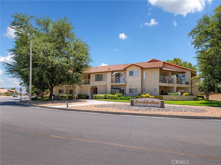 Welcome to this pristine 55+ private community! Just the cutest Condo ever! Hop on the elevator or use the convenient stairs  to arrive at your upper level home that provides more privacy, views and peace of mind!  Several upgrades including Wood like flooring thru-out, fresh paint new appliances and quartz counters in kitchen and baths.  Large great room with room to have a nice dining/eating area. Bedrooms both have their own baths. The rear deck or balcony  looks out to green belt , trees and a peak view of the mountains beyond, perfect for morning coffee or afternoon libations. Indoor laundry to boot!  Assigned carport for 1 car plus a storage cabinet.  The New Club house has just opened with pool and spa for residents only. You will appreciate that water and trash are included and paid for by your HOA dues.