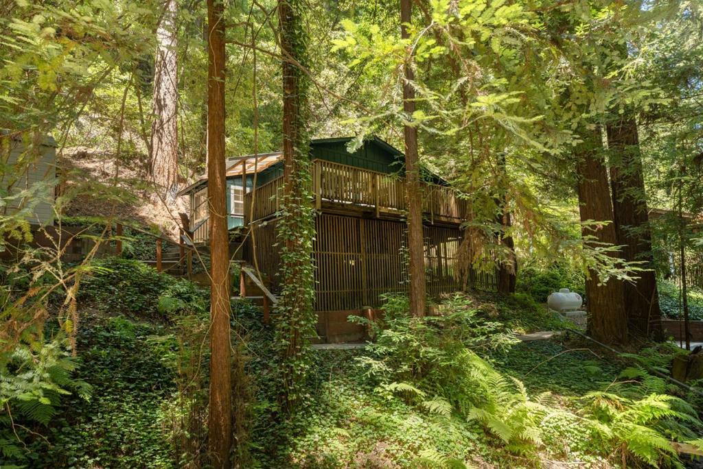VA Assumable Loan with NFCU to Qualified Vet available -- Tucked at the end of a private lane, this renovated and charming cottage escape is a hidden gem located near Henry Cowell Redwoods State Park, Covered Bridge County Park, and Roaring Camp Railroad. Freshly painted inside and out, your home welcomes you with soaring open-beam ceilings, skylights that bathe the home in natural light, and new luxury vinyl plank flooring throughout. The modern kitchen features a new stainless steel refrigerator, granite countertops, stainless steel stove, and an island perfect for food prep and casual dining. The luxe bath offers a granite vanity with vessel sink and soaking tub with shower. Step outside to your spacious deck, breathe in the forest scents, and listen to the babble of the nearby brook as you sip morning coffee under towering redwoods or unwind with wine at sunset. Comfort meets convenience with dual-pane windows, on-demand water heater, newer roof, and inside laundry room. Minutes from downtown Felton, Santa Cruz beaches, and wine tasting rooms, this is vacation living every day, perfect as a full-time residence or weekend escape. Road and drainage were updated after 2023 storms. Fire stations within 1 mile and hydrant on the street provide enhanced safety.