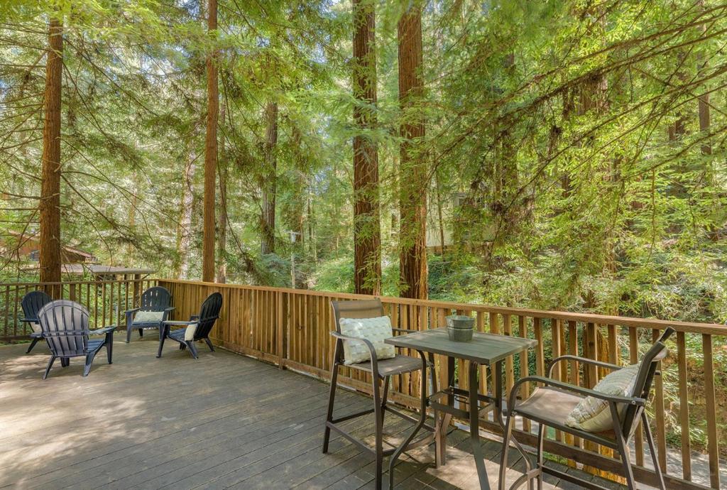 Tucked at the end of a private lane, this charming cottage escape is located near Henry Cowell Redwoods State Park, Covered Bridge County Park, and Roaring Camp Railroads. Freshly painted inside and out, it welcomes you with soaring open-beam ceilings, skylights that bathe the home in natural light, and new luxury vinyl plank flooring throughout. The modern kitchen features a new stainless steel refrigerator, granite countertops, stainless steel stove, and an island perfect for sharing meals. The luxe cottage bath offers a granite vanity with vessel sink and soaking tub. Step outside to your spacious deck, breathe in the forest scents, and listen to the babble of the nearby brook as you sip morning coffee under towering redwoods or unwind with wine at sunset. Comfort meets convenience with dual-pane windows, on-demand water heater, newer roof, and inside laundry room. Minutes from downtown Felton, Santa Cruz beaches, and wine tasting rooms, this is vacation living every day, perfect as a full-time residence or weekend escape. Road and culvert/brook were updated after 2023 storms. Fire stations within 1 mile and a hydrant on the street provide enhanced safety.