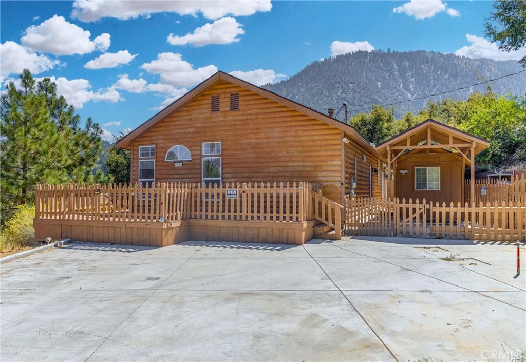 Escape to the top of Zermatt Drive, where breathtaking mountain views frame this single-level manufactured home on a permitted 433A permanent foundation with rustic log siding. Surrounded by lush trees and backing to the peaceful, coveted greenbelt, this property blends privacy, charm, and the sought-after amenities of Pine Mountain Club.
Step inside to a bright, airy kitchen with white cabinetry that opens to the dining and living areas, complete with a cozy fireplace, built-ins, a window seat, and French doors leading to the deck. The spacious primary suite offers private deck access, dual closets, and a bath with double vanities, while a guest bedroom and full bath complete the floor plan.
Recent upgrades since 2020 include a new microwave, new water heater, new water softener, new electrical panel with car charging station, new carpet throughout, fresh paint, and a storage shed equipped with additional engineered wood flooring. Outdoors, enjoy expansive decks for entertaining, a newly poured concrete driveway (2021), a gated backyard for privacy, and a kennel for pets. The propane tank is owned and serviced by Western Propane—no lease required.
Sold as-is and priced to sell—don’t miss out! Ask the listing agent for the home inspection completed in August 2025. Best of all, the home sits on its own 1/3-acre lot with no space rent, while full Pine Mountain Club membership offers resort-style amenities: a sparkling pool, clubhouse, scenic golf course, tennis courts, and 24/7 patrol for peace of mind.
For buyers seeking flexibility, the seller is open to seller financing with a 15-year term, 20% down, 7% interest, and no pre-payment penalty (cross-qualification with the seller’s preferred mortgage company required).
Hike nearby trails, breathe in the crisp pine air, or perfect your swing—this is mountain living at its best. Coming soon—schedule your showing today!