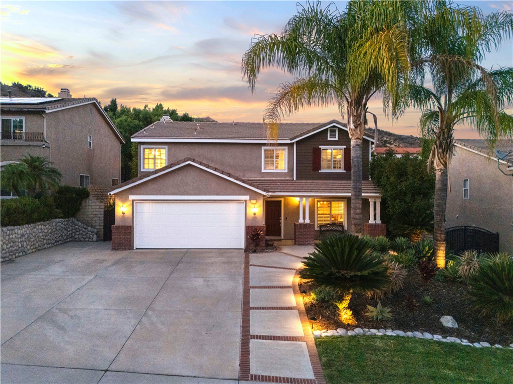 IMMACULATE and REMODELED cul-de-sac home near the top of Hillcrest shows like a model home with NO HOA or Mello-Roos! Pride of ownership is evident and the beautifully landscaped front yard provides great curb appeal with mature palm trees, a river rock wall, and an EXTRA WIDE DRIVEWAY THAT CAN ACCOMMODATE AN RV/CAMPER! Upon entry through the covered front porch, you’re greeted into the light & bright home that's been FRESHLY PAINTED and is adorned with engineered bamboo wood flooring that is durable and water resistant and spans the entire first floor. Your stunning open-concept kitchen has been gorgeously remodeled with espresso soft-close cabinetry with pull out drawers, Ogee edge granite countertops, mosaic tile backsplash, pendant lighting, stainless steel appliances and sink, and a pantry. It opens up to the family room designed for entertaining with a surround sound system, ceiling fan, and a built-in entertainment center surrounding a cozy fireplace. Your first floor also includes a powder room and laundry room complete with plenty of cabinetry, a granite countertop, and a laundry chute from your primary suite. Head upstairs where you’ll find a spacious loft, 4 bedrooms, and 2 full bathrooms. Your primary suite features cathedral ceilings along with a double sink vanity, walk-in shower, soaking tub, spacious walk-in closet, and newly installed tile floors. Plantation shutters, crown molding, and recessed lights adorn the home adding to its beauty. Entertain and enjoy relaxing evenings in your tastefully landscaped backyard featuring outdoor lamp posts, a built-in BBQ, a gas fire pit, river rock planter walls, stamped concrete, raised garden beds with dedicated watering system, and covered patio to enjoy al-fresco dining or watch your favorite sports games on the 45" outdoor TV. Your NEWER AC UNIT IS ONLY ~1 YEAR OLD and provides comfort and energy efficiency year-round. Your two car garage includes a work bench, shelving, and a level 2 EV charging station. Surrounded by award winning schools, parks, shopping centers, dining options, Castaic Lake, and being close to the 5 freeway and highway 126 making commuting quick and easy. Come by and become the lucky new owner of this TURN-KEY home where your story begins!