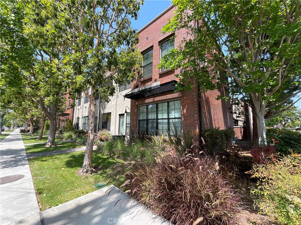 Built in 2007 Live/Work Condo Development in the Old Towne Orange Area. First LEED Certified homes in the City of Orange. On the exterior, you have a Brownstone-inspired look with exposed brick, industrial metal black accent, with large windows facing the street. This corner unit has one of the best views with a front street view of Maple Ave and the Sante Fe Depot Metro Station. Starting from the lower level you have a glass door entrance with a keypad lock. Off the entry, you are greeted with a large room downstairs that can either be used as an office or a bedroom with 2 large windows. Downstairs you have wood-like porcelain tile flooring throughout, an in-unit stacked washer/dryer, with a 1/4 bathroom. Upstairs you have quartz countertops in the kitchen and both bathrooms. Upstairs, the Great Room/Living Room is open to the kitchen with recessed LED lighting and pendant lights above the bar countertop. In the Great Room, you have an electronic starter gas fireplace with carpet throughout, you have 6 large windows overlooking Maple Ave and the Metro Station. The kitchen that is open to the Great Room has a stainless steel dishwasher with a 5 burner gas stove/oven and a brushed metal kitchen faucet with a garbage disposal. Down the hall, you have a separate 3/4 Bathroom. The guest bedroom features sliding closet doors with direct access to the sliding glass door to the private patio. The primary bedroom features 4 large windows with a connected Primary Bathroom with dual vanity sinks and a standalone tub with a separate standing shower. The Master Bathroom also has a connected walk-in closet with a large window facing the train tracks. The home also features dedicated solar panels on the roof that assist in lowering energy costs through NET meters. You also have central heating and air controlled by Nest Thermostat. Downstairs you have direct access to 2 car garage where the tankless water heater is located.