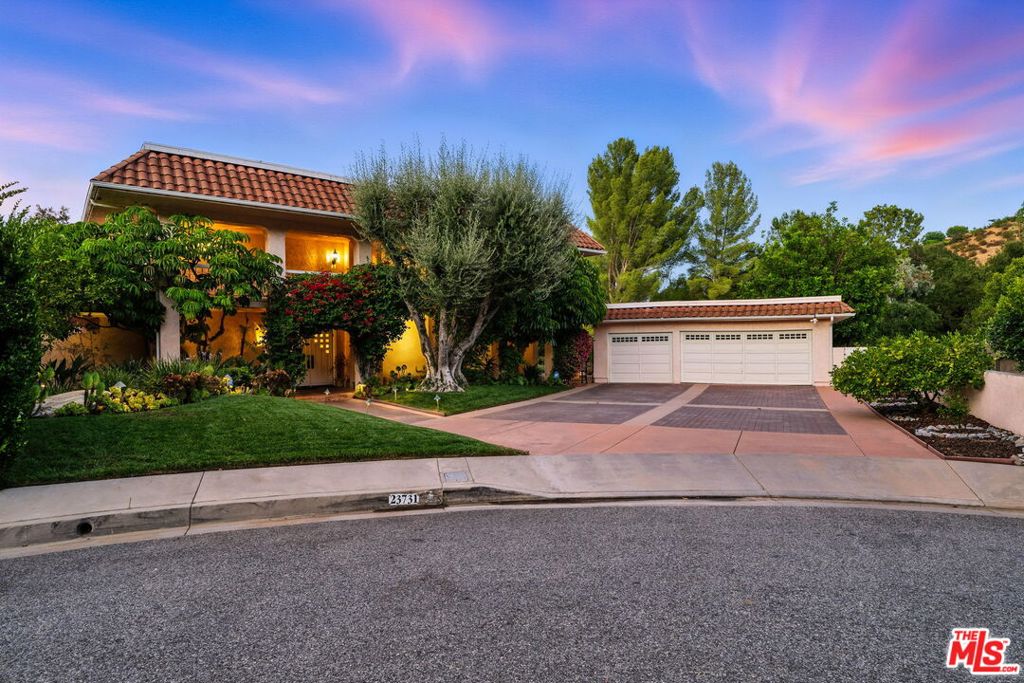 Stunning Hacienda-style residence showcases sophisticated, yet authentic design elements with exceptional views and an impressive yard. Situated on a cul-de-sac, this two-story home features 4 bedrooms, 3.5 bathrooms with timeless character and modern comforts. Meticulously appointed with curated furnishings for a comfortable atmosphere, the well-planned layout flows effortlessly between living spaces, creating perfect harmony between indoor comfort and the spectacular outdoor retreat. Natural light floods the casual living room and elegant dining room, while the chef's kitchen captivates with designer finishes including Taj Mahal quartzite countertops, a soapstone island, and Saltillo tile flooring. The built-in coffee bar adds the perfect touch for morning rituals. A serene seating area off the kitchen with built-in storage and media center can be used as an additional family room. Upstairs, the primary suite offers a serene retreat with a fireplace and private access to an expansive balcony. The spa-like bathroom includes a soaking tub with views, thoughtful storage and a generous walk-in closet. Adjacent to the primary suite is a flexible bonus room currently used as a gym (equipment optional) that can easily serve as an office or recreation room, with access to a rooftop deck. Three additional bedrooms on the main level provide comfortable accommodations and an abundance of storage. Two secondary bedrooms share a bathroom, while the third bedroom is an ensuite. The expansive backyard is perfect for both relaxing and entertaining, featuring a sparkling pool, beautiful landscaping and mature citrus trees throughout. The viewing deck offers incredible views from the valley to the mountains, creating an atmosphere reminiscent of the Ojai Valley Inn sunsets and refined resort-style living. Multiple outdoor spaces create ideal settings for any occasion. Additional features include a security system, Ring doorbell, EV charging capability, and abundant parking with both garage and expansive driveway space. As part of Calabasas Park, residents enjoy HOA privileges including access to the community lake for walking and recreation, plus proximity to upscale shopping at The Commons, award-winning schools in the Las Virgenes Unified School District and top private schools, and great dining options. Flexible term lease. Available fully furnished for immediate occupancy, but will be considered unfurnished if preferred.