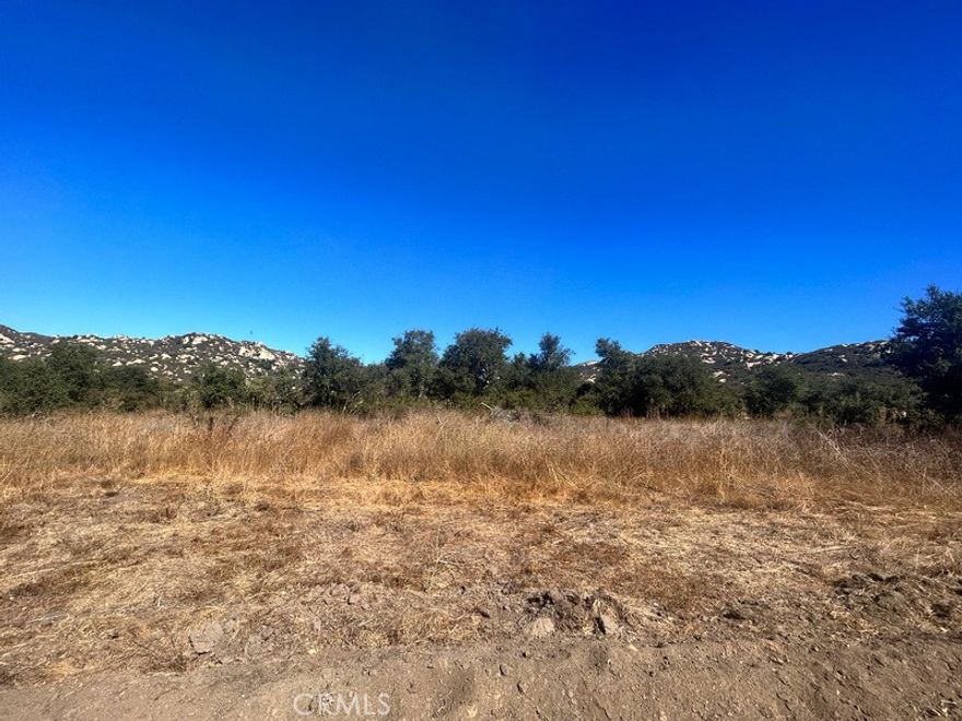 Discover wide-open space and endless potential on this 16.78-acre parcel tucked into the rolling hills of North San Diego County. Set along Rainbow Heights Road, this property combines privacy with accessibility — just minutes from I-15, Temecula wine country, and all the charm of Fallbrook.



The land offers a mix of gently sloping terrain and flat, usable areas, making it ideal for a custom estate, vineyard, equestrian retreat, or sustainable farm. Surrounded by Live Oaks and natural chaparral, the property enjoys a peaceful setting with sweeping mountain views. Utilities are located nearby, and flexible zoning supports a variety of development opportunities.



Whether you envision a private residence, agricultural venture, or long-term investment, this property provides a rare chance to create something truly special in one of San Diego County’s most desirable rural communities.