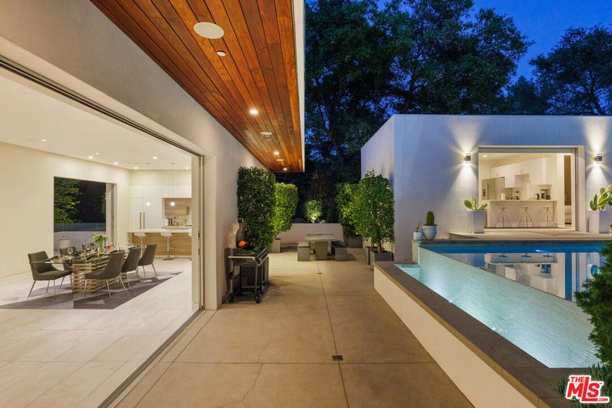 Sherman Oaks compound offering an effortlessly relaxed California lifestyle. Stunning glass walls welcome you into the two-story entry level with a family room, movie theatre, and lavish primary suite. A striking floating staircase leads to the main level, encompassing the living room, dining room, and a chef's kitchen with Thermador appliances and bespoke Italian cabinetry. Expansive Fleetwood pocket doors open to the resort style backyard with infinity pool and spa, multiple grassy areas, and a fantastic 1 bedroom guest house. With Control 4 smart home features, generous parking, captivating views and elevator, this home offers all of the style and amenities you're looking for.