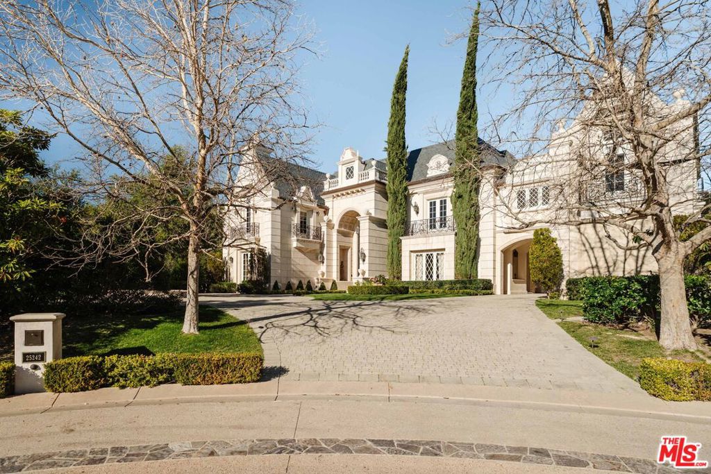 Located behind the sought-after double gates of the Estates of the Oaks, this one-of-a-kind French Country masterpiece sets the bar for the neighborhood. Sitting on just under an acre at the end of the cul-de-sac, the over 14,000-square-foot residence was built with no expense spared, showcasing impeccable craftsmanship, curated finishes, and world-class amenities. Spanning three levels, the main house offers an unrivaled living experience. A grand chef's kitchen is complemented by a secondary full-service kitchen, ideal for entertaining. Two elegant dining rooms, a breathtaking two-story library/study, a state-of-the-art theater, a wine cellar with tasting room, a spacious gym with a sauna, and two executive offices are just a glimpse of the estate's extensive offerings. The grand primary suite enjoys a private wing on the main level, complete with two fireplaces, a separate sitting room, dressing rooms, and dual spa-inspired bathrooms with expansive walk-in closets. Resort-like grounds feature a sparkling pool and spa, an outdoor kitchen, and sprawling manicured lawns. A separate, self-contained guest house includes a large living room with a fireplace, bedroom, dining room, and a kitchenetteperfect for visitors or extended stays. The stately circular driveway, anchored by a majestic oak tree, leads to a porte-cochre and a four-car garage. Opportunities to own a home of this caliber are exceedingly rare, especially within this prestigious community. This is truly one of Southern California's finest estates.