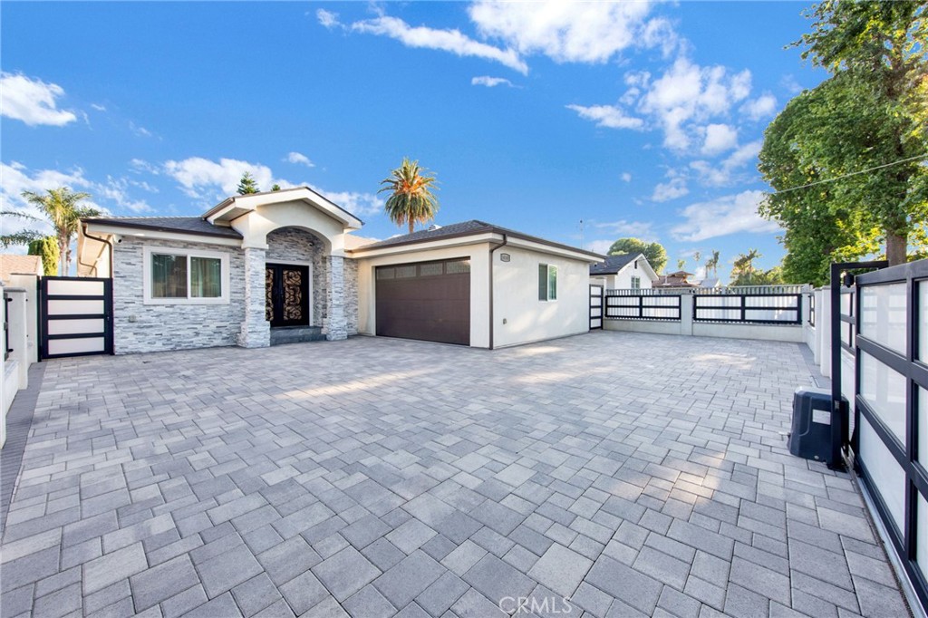 Welcome to this stunningly Newly Rebuilt in 2018 single-story home in the vibrant neighborhood of Van Nuys! As you approach the modern and sleek gates, you'll immediately feel the allure of this residence. The home boasts a spacious 3 bedrooms, 2.5 bathrooms, Family Room, large Living Room, Very Bright Eat-In Kitchen, Outdoor Patio Area, Large maintenance free Back Yard, Attached 2 Cars Garage, which also has been insulated, drywalled, Recessed Lights and ready to convert it to ADU. Upon stepping inside, you'll be captivated by the expansive open floor plan, adorned with recessed lighting throughout, beautiful modern tile flooring and high quality of Millgard energy efficient Windows that flood the space with natural light. The kitchen is a true masterpiece, featuring exquisite countertops and a stylish island, complemented by stainless steel appliances. The kitchen offers both practicality and elegance, providing ample storage space in the numerous cabinets. The primary suite is a tranquil retreat, boasting a generously sized bedroom and an en-suite bathroom that exudes luxury. Pamper yourself in the soaking tub or enjoy the convenience of a stand-up shower, all accompanied by dual sinks for added convenience. The two additional bedrooms in the main home are spacious and offer sliding closet doors, ensuring plenty of room for storage and personal belongings. Exit outside through the family room or the hall way to discover a true entertainer's paradise. The backyard features a covered patio area perfect for hosting gatherings and creating lasting memories with guests. Nestled in the very quiet street. It comes with comfort, style, and modern living in Van Nuys.