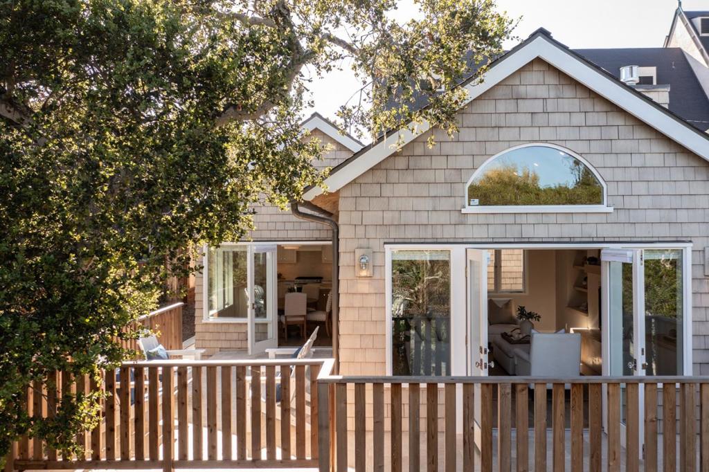 Nestled in the heart of downtown Carmel-by-the-Sea, this newly constructed, exquisite 4-bed, 3.5-bath luxury cottage is a rare blend of Carmel charm and refined craftsmanship. Designed by renowned architect Claudio Ortiz, every detail speaks to timeless elegance and California coastal living. Through the arched front door you are welcomed into a warm and inviting stained redwood accented home with a vaulted-ceiling living room adorned with custom shelving, gas fireplace, and radiant hydronic heat beneath engineered wood floors. The gourmet kitchen features a quartzite Taj Mahal island, skylights, and seamless flow to an Italian travertine deck, perfect for indoor-outdoor entertaining. Large windows with custom UK-imported hardware flood the home with southeast light. The main-level primary suite has a spa-like bath with a walk-in shower, underlit honey onyx counters, and a walk-in closet. Downstairs offers 3 bedrooms, a laundry room, family room, and 2 guest baths. Thoughtful details include a fresh air system, solar efficiency, tankless water heater, grade level 5 hand-troweled walls, and Montebella onyx bath counters in the guest bathrooms. With restaurants, shops, and beaches within walking distance, this is the perfect place to unwind after exploring Carmel.