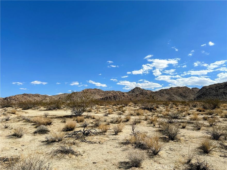 Incredible 2.5 acre corner lot on the South side of 29 Palms Hwy. Prime location with unobstructed panoramic views to rocky mountains in Joshua Tree National Park. Power close by, drill a well for water. Short drive to Joshua Tree Village shops, attractions, and amenities. Property does not have an assigned address - for listing purposes only. APN: 0608-111-31-0000. GPS: (34.1281966, -116.2081359). Take a look at this one today!