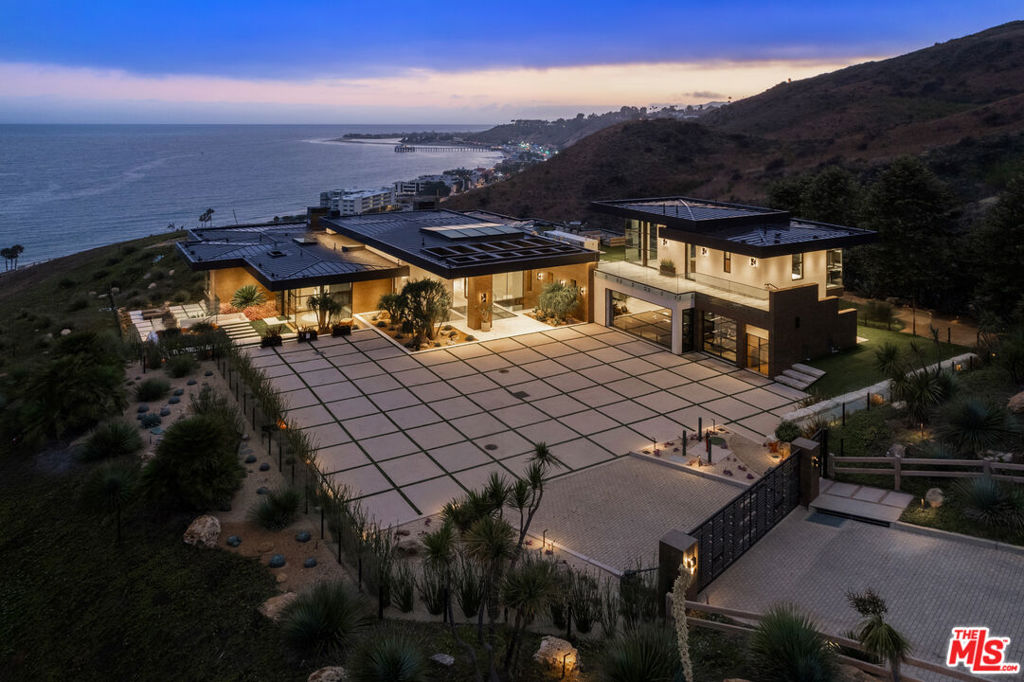 Perched high above the coastline with commanding, unobstructed views of Carbon Beach and the iconic Malibu Pier, this newly constructed estate is a true architectural triumph. Set on over 22 acres within the exclusive Carbon Beach Terrace Estates, the property is accessed through dual gates with 24/7 security and introduced by a dramatic glass entryway featuring an oversized pivot door and soaring ceilings. Designed with impeccable taste, the home is filled with natural light and finished with sophisticated furnishings and high-end materials. Every element has been thoughtfully curated from the statement-making glass staircase to the bespoke detailing throughout. The open-plan living spaces seamlessly blend modern comfort with refined luxury, creating a warm yet elevated atmosphere. The primary suite offers a peaceful retreat, complemented by a gourmet chef's kitchen, state-of-the-art cinema, private poker room, and luxury wellness amenities including a fitness center, indoor spa, steam room/sauna, hair salon, and private massage area. Outside, an infinity-edge pool with jacuzzi, expansive terraces with fire pits, and a private sandy beach provide the perfect setting for both relaxation and entertaining. Guest accommodations include private quarters with a stunning rooftop deck that rivals a five-star resort. Located just minutes from Nobu, Soho House, and Malibu's most celebrated destinations, this exceptional property offers an unrivaled coastal lifestyle defined by privacy, design, and world-class views.