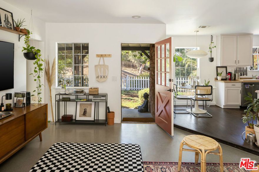 Tucked away on a peaceful Sunland street and perched on a gentle hillside in the foothills of the San Gabriel Mountains, this inviting ranch-style home blends classic charm with modern comfort. The spacious, open-concept layout is filled with natural light, featuring newly poured concrete floors, recessed lighting, and a mid-century fireplace in the living room. French doors open to a covered patio overlooking a large, usable lot with mountain and canyon views. The kitchen includes stainless steel appliances and ample cabinetry, while the private primary suite offers a serene retreat. Two additional bedrooms and a full bath provide flexibility for guests or a home office. Outdoors, enjoy lush landscaping, a white picket fence, and endless potential add a garden, build a pool or ADU, or create your own backyard oasis. Conveniently located near Burbank, Glendale, and La Crescenta, this Sunland home offers the perfect Los Angeles hillside retreat.