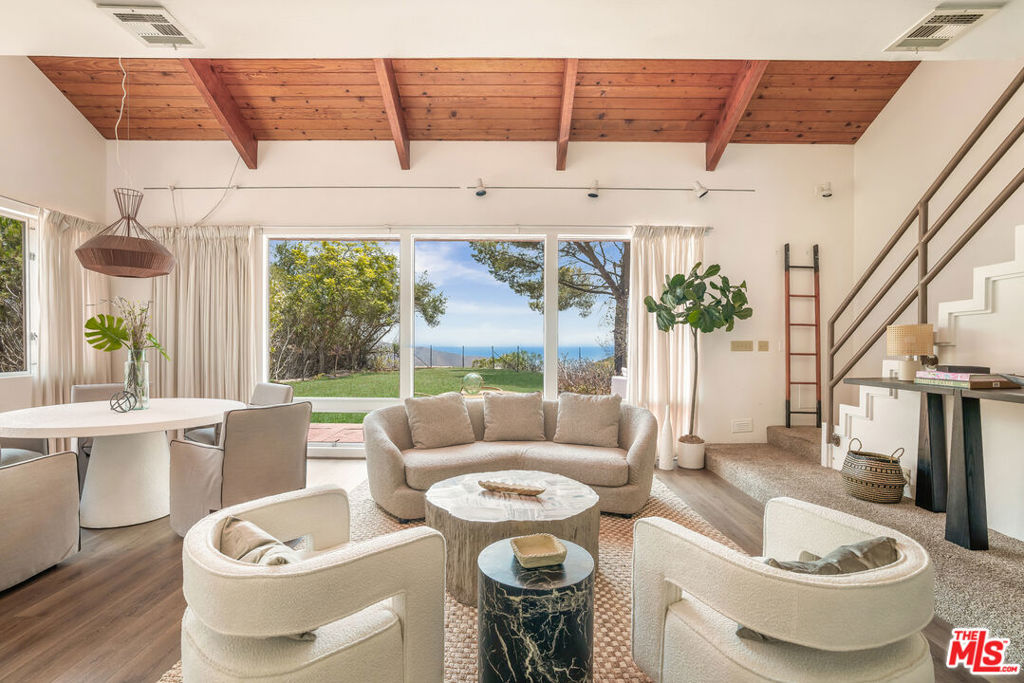 Discover this rare Malibu retreat, a 3-bedroom, 2-bath single-family home with breathtaking ocean views, set on a private one-acre plus lot (45,097 sq ft) at the end of a secluded street. Built in 1974, the 1,484 sq ft residence blends vintage Malibu character with modern potential. Expansive windows flood the home with natural light, framing views of the Pacific and the surrounding canyon where hawks and owls glide above fresh wildflowers. The primary suite opens to a spacious ocean-view balcony, perfect for relaxing and taking in Malibu's sunsets. A large, flat area on the property offers exceptional privacy and space for outdoor living, gardens, or potential future expansion. Additional features include a two-car garage and a peaceful location just minutes from Malibu's most beloved beaches at La Costa Beach, Big Rock, the Barefoot Bar at Duke's, as well as the Pacific Coast Highway for easy access to Santa Monica and beyond. Live the Malibu lifestyle: ocean breezes, nature's beauty, and the timeless soul of the 70s.