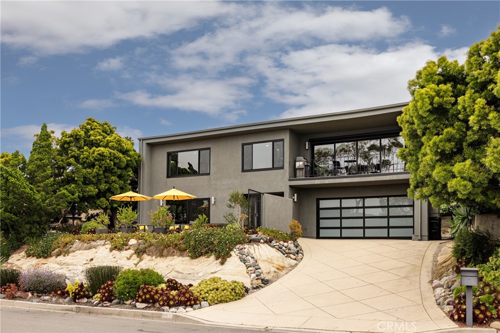 This luxurious remodeled home is in the scenic private neighborhood of Top of the World in Laguna Beach, offering a blend of coastal elegance, modern comfort and ocean views. Enjoy colorful magical sunsets from this home in one of the friendliest locations Laguna has to offer. This spacious lot boasts manicured landscaping and a panoramic ocean view front patio area for outdoor entertaining. The downstairs level is private with two comfortable bedrooms with new large windows, extra closet space and 1.5 baths. The upstairs level is a comfortable and stylish space, perfect for relaxing or entertaining guests with stunning ocean and hill views. The kitchen is a chef's dream, equipped with high-end appliances, granite countertops, custom cabinetry and open to the great room. The primary suite is a serene retreat with a beautiful black and white tiled ensuite bathroom. The light and bright guest bath has dual sinks and a shower. The home is equipped with air conditioning and a dedicated laundry room. The garage offers plenty of storage and off-street parking. Situated in the exclusive neighborhood of Top of the World, the home is walking distance to miles of hiking trails in the natural preserve in addition to a park with tennis/pickle ball courts, soccer/baseball fields and a children's dream playground. The California Distinguished awarded elementary school of Top of the World Elementary is close by. Down the hill are Laguna Beach's renowned beaches, hiking trails, and vibrant downtown area. Residents can easily access amenities such as boutique shops, art galleries, restaurants, and cultural attractions. A trolley and free local ride service are available to travel anywhere in Laguna Beach.