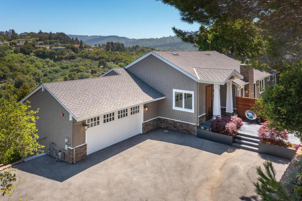 Set on a generous and private 0.69-acre lot with breathtaking views, this lovely updated 4-bedroom, 2.5-bath home offers the perfect blend of modern comfort and timeless elegance. Designed for today's lifestyle, it features light-filled interior spaces and a seamless flow ideal for entertaining. Highlights include chic flooring, tray ceilings, recessed lighting, and expansive picture windows framing the lush, natural surroundings. The open-concept dining area, complete with a fireplace, is accented by French doors that open to a sizable patio and level lawn, perfect for indoor-outdoor living. The chef's kitchen boasts a center island and top-of-the-line appliances, flowing effortlessly into a spacious great room with direct access to a large deck showcasing spectacular views. 3 bedrooms and 2.5 baths are conveniently located on the main level, including a luxurious primary suite with a large walk-in closet and a spa-inspired bath. A 4th bedroom is located on the lower level, offering flexibility for guests, a home office, or additional living space. A long, sweeping driveway bordered by manicured boxwood hedges, vibrant rose bushes, and elegant Japanese maples leads to a 2-car garage with additional storage, completing the appeal of this exceptional, turnkey property.