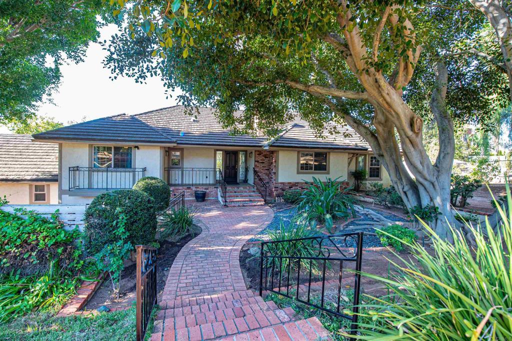 Stunning Tudor-Style Estate on Over Two Acres with Exceptional Views and Versatile Living Spaces Welcome to this one-of-a-kind Tudor-style estate, nestled on more than two fully landscaped acres with breathtaking mountain and estate views. The main residence spans over 3,400 square feet and is filled with charm, elegance, and thoughtful updates. Step into the oversized great room where vaulted ceilings and expansive windows create a dramatic, light-filled space that never fails to impress guests. Recent renovations include luxury vinyl plank flooring throughout the main areas and plush new carpeting in both main-floor bedrooms, offering comfort and style. The spacious kitchen is perfect for entertaining and flows seamlessly into a charming sunroom. From there, enjoy serene views of the beautifully manicured backyard and the surrounding natural beauty. Downstairs, a separate living area with a private entrance offers flexible use as a potential in-law suite, guest quarters, or rental unit—ideal for multigenerational living or added income potential. A detached structure houses a generous four-car garage and an attached ADU. The ADU includes a stunning upstairs bedroom with vaulted ceilings, a full bath, walk-in closet, and a private balcony with panoramic views. A second full bathroom is located on the ground floor for added convenience. Car enthusiasts and hobbyists will appreciate the massive 45’ x 40’ multipurpose building—perfect for additional vehicle storage, a workshop, or even hosting events. This versatile space sits just beyond a tranquil pond, home to fish and visited by ducks year-round. The estate features 36 fully paid-for solar panels, significantly reducing energy costs. The entire property is fully fenced and gated, providing both security and peace of mind. Outdoor enthusiasts and gardeners will love the lush, mature landscaping, complete with flowering plants, trees that attract birds and butterflies, and a mini orchard featuring four prolific avocado trees, citrus trees, an Asian pear tree, pomegranate tree, and two macadamia nut trees. With abundant storage, potential for additional ADUs, and a layout ideal for multigenerational living, this property is truly unlike anything else on the market in the area. If you’re seeking an extraordinary estate that offers both luxury and flexibility, look no further—this is the home for you