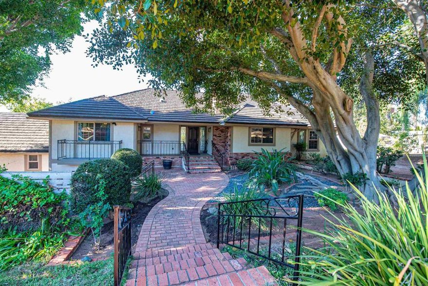Stunning Tudor-Style Estate on Over Two Acres with Exceptional Views and Versatile Living Spaces  Welcome to this one-of-a-kind Tudor-style estate, nestled on more than two fully landscaped acres with breathtaking mountain and estate views. The main residence spans over 3,400 square feet and is filled with charm, elegance, and thoughtful updates.  Step into the oversized great room where vaulted ceilings and expansive windows create a dramatic, light-filled space that never fails to impress guests. Recent renovations include luxury vinyl plank flooring throughout the main areas and plush new carpeting in both main-floor bedrooms, offering comfort and style.  The spacious kitchen is perfect for entertaining and flows seamlessly into a charming sunroom. From there, enjoy serene views of the beautifully manicured backyard and the surrounding natural beauty.  Downstairs, a separate living area with a private entrance offers flexible use as a potential in-law suite, guest quarters, or rental unit—ideal for multigenerational living or added income potential.  A detached structure houses a generous four-car garage and an attached ADU. The ADU includes a stunning upstairs bedroom with vaulted ceilings, a full bath, walk-in closet, and a private balcony with panoramic views. A second full bathroom is located on the ground floor for added convenience.  Car enthusiasts and hobbyists will appreciate the massive 45’ x 40’ multipurpose building—perfect for additional vehicle storage, a workshop, or even hosting events. This versatile space sits just beyond a tranquil pond, home to fish and visited by ducks year-round.  The estate features 36 fully paid-for solar panels, significantly reducing energy costs. The entire property is fully fenced and gated, providing both security and peace of mind.  Outdoor enthusiasts and gardeners will love the lush, mature landscaping, complete with flowering plants, trees that attract birds and butterflies, and a mini orchard featuring four prolific avocado trees, citrus trees, an Asian pear tree, pomegranate tree, and two macadamia nut trees.  With abundant storage, potential for additional ADUs, and a layout ideal for multigenerational living, this property is truly unlike anything else on the market in the area.  If you’re seeking an extraordinary estate that offers both luxury and flexibility, look no further—this is the home for you