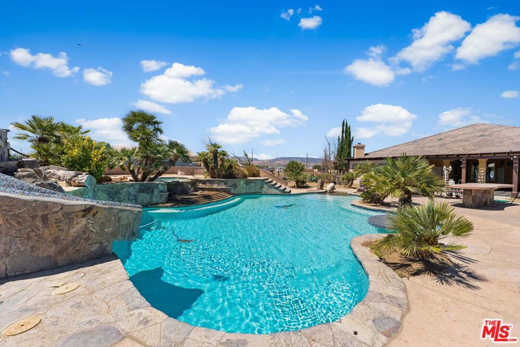 Experience refined desert living at its finest at 42094 W 21st St in prestigious West Lancaster. Set on an expansive 2.3-acre estate, this elegant custom-built residence offers 3,768 sq ft of masterfully designed living space with 4 bedrooms and 5 luxurious bathrooms. Featuring two junior suites with private baths, this home provides seamless comfort for extended family or guests. Crafted with high-end finishes, the chef's kitchen is the heart of the home offering top-tier appliances, a spacious island, and exquisite cabinetry perfect for entertaining or intimate evenings in. Retreat to the bonus room, ideal for a home theater, studio, or executive office. The living space effortlessly flows outdoors to a custom-designed pool and expansive grounds a true entertainer's dream with space to build or personalize even further. The oversized 3-car garage offers ample storage and flexibility for your lifestyle. Situated near the renowned Antelope Valley Winery, Antelope Valley Mall, and fine dining, this estate balances serene privacy with easy access to local attractions. Don't miss the opportunity to own a rare luxury property with land, style, and sophistication.