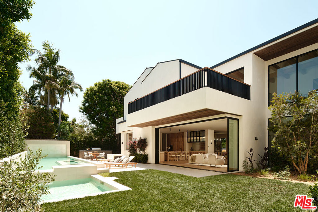 Just completed architectural marvel embodies the essence of the the California Modern aesthetic in a peaceful Brentwood cul-de-sac moments from the Riviera Country Club. Impressive in scale and design, the extraordinary 9,139 square-foot residence combines luxurious comforts with natural elements like honed stone surfaces, bespoke millwork, and seamless indoor-outdoor living. The inviting main level gleams with radiant natural light from large windows and retractable glass walls flowing into a private, hedge-lined backyard. Ideally equipped for grand events or intimate gatherings, the great room features a living area centered on a floor-to-ceiling travertine fireplace, a gourmet kitchen with double islands, Thermador appliances, custom cabinetry, and a butler's pantry, and the dining room with a wet bar. A chic glass-enclosed office, guest suite, and powder bath complete the main level. Subtle yet striking, the stairway is lined by two-story windows and set beneath robust wood-beamed ceilings. Ascend to a family room with balcony access and four bedroom suites, inclusive of the primary sanctuary. Achieve repose amongst the primary suite's distinctive features like the stone fireplace, personal wet bar, expansive custom closet, and spa-like bathroom. A versatile combination of entertaining space and a lavish wellness retreat, the lower level offers a temperature-controlled wine room with a custom bar, a lounge, a movie theater, a gym, and a home spa with a meticulously crafted sauna and steam room. Outside, thoughtfully curated landscaping including a fairytale-like smoke tree, mature olive tree, tall hedging, and natural grasses extend the refined interior design outdoors. Revel in California's eternal sunshine or dine al fresco beside the sparkling pool, spa, and built-in outdoor kitchen. Other notable features include state-of-the-art home tech with the home automation system, smart thermostats, solar system, and surround sound, along with service quarters, dual laundry rooms, and an attached two-car garage. Supremely located in the Westside's most coveted neighborhood, residents enjoy convenient access to Riviera Country Club, Brentwood Country Mart, Palisades Village, and the beach. Refined in style and unparalleled in craftsmanship, this timeless California Modern residence presents the rare opportunity to step outside of the ordinary and realize the dream Westside lifestyle.