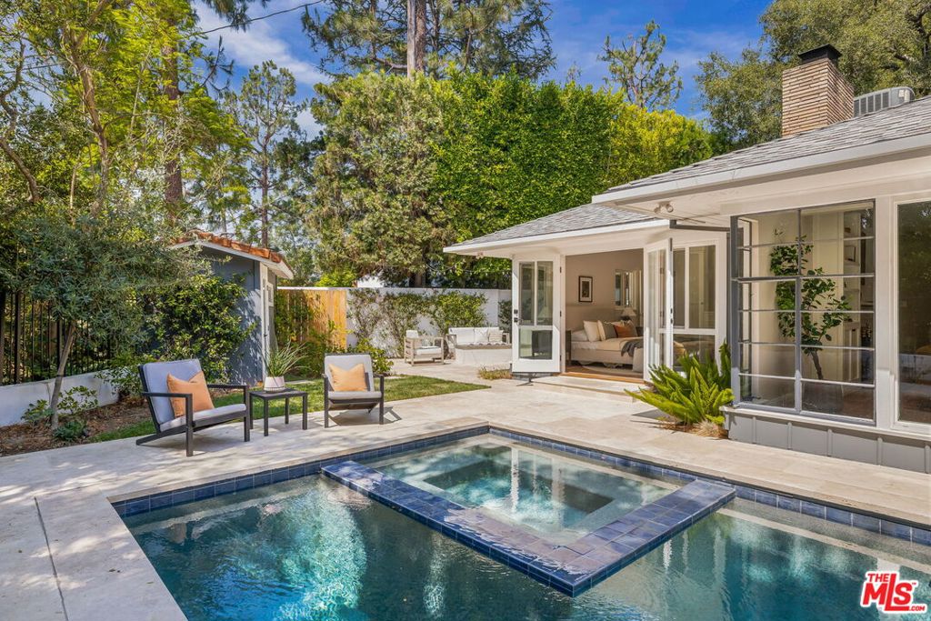 This must-see mid-century ranch, set on a serene half-acre in the Studio City hills, embodies the essence of California living. Featuring three bedrooms including a primary suite, two baths, and a stylish guest powder room, the home blends classic architecture with modern design. An open-concept layout, hardwood floors, and premium finishes create an inviting, timeless feel. All main living spaces including the living room/dining area, kitchen, and primary bedroom open to the beautifully landscaped backyard, where a sparkling pool & spa and generous patio/seating areas set the stage for true indoor-outdoor living. Abundant natural light enhances every room. A private driveway offers added peace and security. A bonus yard provides space for a garden and your own dog park or play area. Located in the sought-after Carpenter School District and just minutes from Ventura Boulevard's dining and shopping, this is a rare opportunity to own a piece of Studio City perfection.