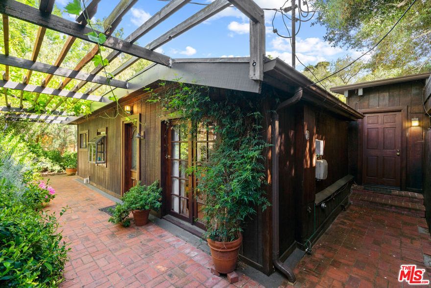 Charming 1920s Topanga Canyon Retreat - A True California Gem. Step into the serene beauty of Topanga Canyon and discover this enchanting 1920s-style home, nestled beneath the shade of ancient oaks with a seasonal creek that meanders through the lower yard. This unique property blends classic character with the natural beauty of its surroundings, offering a perfect retreat for artists, nature lovers, or anyone seeking a peaceful, canyon lifestyle. Inside, the home exudes warmth and charm with high, beamed ceilings, wood and brick floors, and French doors in every room that open to spacious upper and lower decks, inviting the outdoors in and bathing each space in natural light. The living room, anchored by a cozy fireplace, is perfect for gatherings or quiet evenings at home. The large eat-in kitchen is a dream for cooks, featuring abundant counter space and an open layout that flows seamlessly into the dining room, ideal for entertaining or family meals. This home offers two bedrooms and two bathrooms, plus a flex space that could serve as a charming reading nook, home office, or nursery. Every detail of the home evokes the warmth of a bygone era while offering modern comforts for today's living. Step outside and experience the tranquility of the canyon: upper and lower decks overlook the surrounding trees, the shaded yard offers room for gardening or simply relaxing, and you're just minutes fromTopanga State Park's renowned hiking trails. A carport,laundry room, and quiet location complete this exceptional offering.