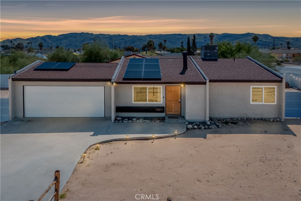 Nestled in a quiet, sunlit neighborhood just minutes from the north entrance of Joshua Tree National Park, this 2-bedroom, 1-bath home presents a seamless blend of modern comfort and relaxed desert charm. As you enter, you’ll feel the calm of the neutral color palette, soft natural light, and an open layout that creates a sense of effortless flow. The living and dining areas are connected, making it easy to host or lounge with ease. Vaulted ceilings add roomy height, and updated windows bring in gentle breezes and desert views. The kitchen is well appointed and designed to be both functional and welcoming. Ample cabinetry, updated appliances, and a breakfast nook/open dining spot near the back patio make daily life comfortable and inviting. Each bedroom retains a serene, understated feel while being flexible enough for guest or personal use. The bathroom is clean and bright, with an expanded walk-in shower newly tiled to the ceiling. Outdoor living is effortless — step out to the patio for morning coffee or evening stargazing. The fenced yard invites desert landscaping, creative outdoor setups, or relaxing in privacy. Located close to local shops, easy access routes, and the natural wonders of the high desert, it offers both serenity and convenience; this home is an ideal full-time residence, desert getaway, or investment opportunity.
