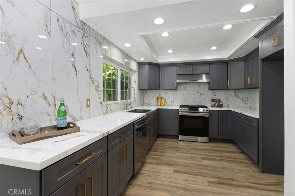 Nestled on a serene cul-de-sac within the coveted inside loop of Woodbridge, this beautifully updated 4-bedroom residence offers a perfect blend of timeless design, thoughtful upgrades, and the elevated lifestyle that makes Irvine one of the most desirable places to live. Just moments from North Lake, this home enjoys the rare combination of tranquil surroundings and resort-style amenities right at your doorstep. Step inside to discover a spacious living room with dramatic vaulted ceilings, creating an airy, sun-drenched welcome. A central atrium brings the outdoors in, filling the home with natural light and a sense of calm. With a downstairs bedroom ideal for guests, extended family, or a home office, the layout offers both flexibility and function. At the heart of the home is a gorgeous remodeled kitchen, where shaker-style cabinetry, nano quartz countertops, and stainless steel appliances combine for a refined yet highly functional space. Designed for both everyday living and entertaining, the kitchen opens seamlessly to the private backyard, complete with an Alumawood patio cover—perfect for outdoor dining, relaxing in the shade, or gathering with friends. Additional highlights include a fully upgraded 200-amp electrical panel, a Level 2 Tesla charger, newer wood-look porcelain tile flooring downstairs, luxury vinyl plank flooring upstairs, remodeled bathrooms with modern finishes & bidets, fresh interior paint, a newer AC system, and fully paid-off solar panels—offering both energy efficiency and long-term savings. Located within the award-winning Irvine Unified School District and just a short walk to Eastshore Elementary, this home also offers easy access to the 405 and 5 freeways, ensuring everyday convenience and seamless commuting. As a resident of Woodbridge, you'll enjoy an unmatched lifestyle with access to two lakes with docks, beach lagoons, 22 pools (many heated year round), 23 tennis courts, scenic trails, parks, and playgrounds—creating a true sense of community and a vacation-like atmosphere year-round. This is more than a home—it’s a chance to be part of one of Irvine’s most beloved neighborhoods. Come experience the charm, comfort, and community of Woodbridge. Schedule your private tour today.