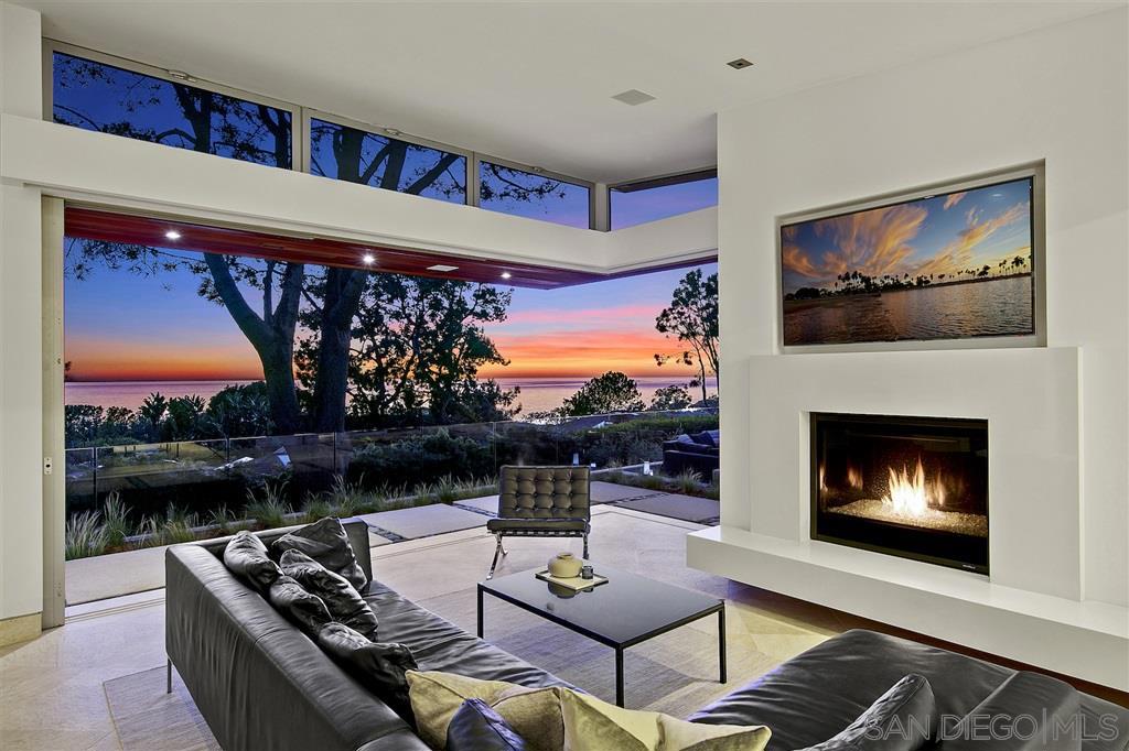Quintessential beauty, amazing sunsets and a perfect Olde Del Mar location make this coastal modern home an incomparable choice for discerning entertainers or family get-togethers. Designed by architect Ronald Wilson, this 5 bedroom, 5.5 bathroom home, on a sweeping 14,500-square foot lot, is cleverly tucked into the natural landscape and flanked by soaring Torrey Pines. Offering panoramic ocean views throughout, this home is the place your friends and family will be drawn to. See supplement... This home invites guests with a bridge spanning the infinity-edge pool where you will be intrigued by a glimpse of the living areas below, through a window in the pool. Continue through the tranquil central courtyard flanked by waterfall features and travertine wall. From the oversized glass pivot entry door, you will be drawn into the open planned living space, captivating you with unparalleled panoramic ocean views from the family room, kitchen, dining room and wraparound bar. The disappearing glass doors truly bring nature inside this light-filled space. Refined elegance and warmth define the large kitchen, featuring walnut cabinetry, a 48" Subzero Professional Series Fridge/Freezer, 8-burner Wolf Professional gas range, and double oven, built-in Miele coffee machine, two Miele dishwashers, and reverse osmosis filtration system with Instant-Hot. With huge disappearing picture windows, recessed lighting, hidden pantry, an ample floating prep island with waterfall-edged attached marble dining table for 6 and Walker Zanger floors, this kitchen envelopes guests in its bounty. Step to the adjacent bar, equipped with its own Sub Zero Fridge & Ice Maker or move to the family room, with its gas fireplace and Panda custom pocket doors, with all-around breathtaking views of the Pacific. The luxurious master suite boasts floor-to-ceiling glass doors and windows opening to the deck, truly marrying the inside with the outside of this space. Attached is the spacious master bath ret...