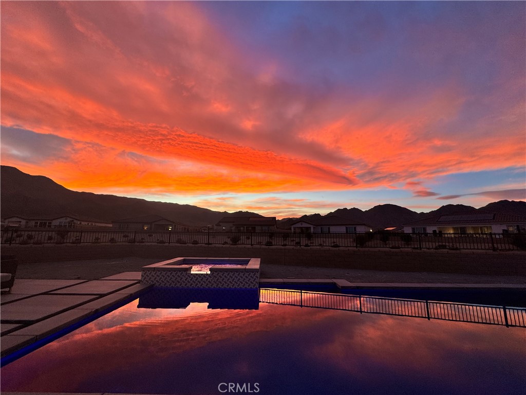 THIS IS THE BEST LOT IN THE TRACT! THE ONE YOU HAVE BEEN WAITING FOR!!! Located near Coral Mountain with Incredible Sunset & Mountain Views on a HUGE pie-shaped lot at the end of a CUL-DE-SAC!! Room for a putting green, sports court, and more! Available NOW! This Brand New Single-Story Energy Star home offers an open-concept chef's kitchen with professional grade Kitchen Aid appliances, a HUGE center island, and a great room with a covered patio outside to enjoy the desert lifestyle. A separate den has French doors to provide a professional and private space for hybrid work and could also serve a dual purpose as the 4th bedroom. Lots of space in the 3-car garage with epoxy floors and built-in cabinetry and the almost 14,000+ sq ft lot provides a HUGE newly built pebble tec pool with a raised spa with a water spillway and outdoor built-in fire pit for enjoying the quiet, peaceful desert nights outdoors and stargazing! This home is located near Coral Mountain in Cantera by Beazer Homes. Loaded with upgrades including quartz counters, designer backsplash, laminate wide plank extra long wood flooring, designer tile in bathrooms, custom paint, large baseboards, Smart Tv's in each room, ceiling fans, alarm system, and cameras throughout outside for added security, built-in closets in every room and so much more!!! Won't Last! This home can be sold fully furnished and ready for you to enjoy with all new designer furnishings. This home won't last and is a MUST-SEE!
