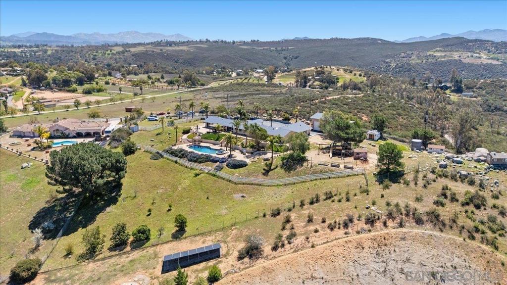 SPACIOUS-PRIVATE-VIEWS Move-in-ready lifestyle-rich property! 2-on-1 stunner! The main home 3/3 boasts expansive living spaces & grand bedrooms. Perfect for spreading out & stylish gatherings. The chef's kitchen is loaded w/ counter space & storage, ready for culinary magic. Take in sweeping views from every angle. Indoor-outdoor flow leads you to the BBQ, sparkling pool, & playground. The ADU 2/1 offers rental income or generational living. Oversized garage & 5 sheds (1 fully finished!) add more flexibility. Owned solar! - Over $300K of improvements put into the property over the last 5 years - Ask for the features & upgrades list - Check out the 3D Virtual Tour. The Main Home is a 3 bed 3 bath. The ADU is a 2 bed 1 bath. Combined that is 4485 sqft of living space. 4 acres of land. Solar is owned! Plug in your EV! If there was a picture for 'Pride of Homeownership', this property is that picture! Admire the infinite views from the home, from the pool, or from the top of the hill in one of the sheds (you can even see Mount Woodson)! Relax in the jacuzzi or refresh your self in the pool! Lose yourself in projects in the gigantic 1000 sqft fully-finished garage workshop! Create your space in the fully finished Flex building! Pick fresh citrus fruit & delicious avocados from the trees! Grow your vegetable garden! Let the kids play in the recently refinished playground for hours! Enjoy horse riding in the community! On one side go to the San Diego Safari park on the other go to Ramona just minutes away. And the list goes on ...
