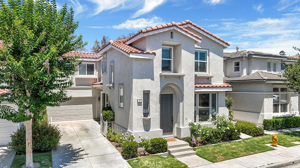 Explore this thoughtfully designed 3-bedroom, 2.5-bathroom home with a spacious loft/optional 4th Bedroom and versatile bonus area, tucked into the sought-after Traditions enclave of Las Flores. Blending timeless style with functional living, this home offers a harmonious mix of comfort and sophistication—designed for both everyday ease and effortless entertaining. The remodeled kitchen makes a lasting impression with ceiling-height cabinetry, granite countertops, stainless steel appliances, and a classic tile backsplash. Natural light floods the adjacent dining and living areas, creating a seamless indoor-outdoor flow ideal for relaxed gatherings or cozy nights in. Upstairs, the primary suite is a true retreat with vaulted ceilings, new plantation shutters, dual sinks, a soaking tub, separate shower, and a well-appointed closet. Two additional bedrooms offer sweeping treetop and sunset views, built-in closet systems, and ceiling fans for year-round comfort. The generous loft space features custom built-ins, desks, and a striking wood accent wall—perfect for a home office, playroom, or optional fourth bedroom. The secondary bathroom has been fully remodeled with herringbone tile flooring, a dual-sink vanity, and modern fixtures. A dedicated upstairs laundry room with tile flooring and attic access adds convenience. On the main level, travertine-look tile complements plush carpeting in the living and family rooms for a warm, grounded feel. Enjoy the private backyard, where tranquil sunset and hillside views offer a peaceful backdrop for unwinding or entertaining. The extra-long driveway enhances both privacy and curb appeal. Ideally located just minutes from shopping, dining, the 5 Freeway, and 241 Toll Road, this home is part of the vibrant Las Flores community, where residents enjoy access to Blue Ribbon schools, scenic parks and trails, a resort-style pool and splash pad, and cherished neighborhood events like Poolside Music, Oktoberfest, Spring Celebration, and Snow Day. Coastal living, community connection, and timeless comfort—all in one place. Welcome home!