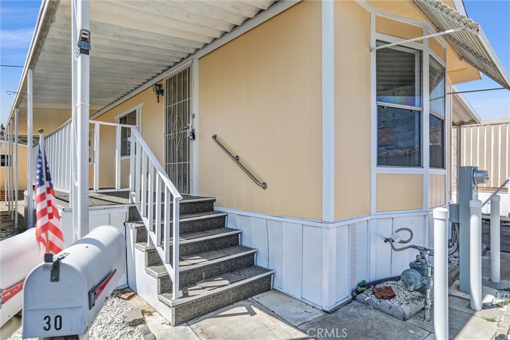 This unit has 2 bedrooms and 1 bath plus a large enclosed sun room patio space for all your storage needs! Both the interior and exterior of the unit have been freshly painted and exterior steps and patio have been newly carpeted. The kitchen and living area have vaulted ceilings and there are plenty of windows that provide natural light. The covered carport leads you to a second entry way that allows you to enter the home from the back enclosed patio that has brand new carpet and two built in storage areas. There is also an oversized shed in the back easily accessible by stone paper walkway. The park is a 55+ community that has has a clubhouse and pool with regularly scheduled activities for residents.