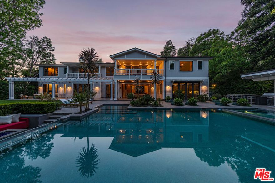 This is an incredible opportunity to own a private and secure Brentwood estate tucked within the prestigious Grove Estates enclave. This expansive 14,000-square-foot residence sits behind gates and offers sweeping canyon vistas and striking views of the Getty Center. A dramatic entrance welcomes you with soaring ceilings, a statement skylight, and a dazzling chandelier centerpiece. The kitchen is a truly exceptional space for hosting and gathering, featuring a distinctive U-shaped island and double sets of top-tier Viking and Sub-Zero appliancesdesigned with the entertainer in mind. Set on a just-over-half-acre lot, the outdoor space is a private retreat complete with resort-style pool and spa, built-in BBQ, open-air kitchen, outdoor media lounge, and a grassy yard framed by majestic mature Oak trees. The main floor includes an elegant formal dining room, a family lounge featuring handmade artful wall coverings by de Gournay, kitchen, and mini-suite guest accommodations all thoughtfully laid out to enhance everyday living and entertaining. The lower level is an entertainer's dream. It currently features a well-sized indoor basketball courtoriginally built as a lap pool and easily converted back at the new owner's discretion. This level also includes a spacious gym, dry sauna, fully equipped bar, 500-bottle wine cellar, private movie theater, putting green for golf enthusiasts, and collector's garage with capacity for 10 vehicles. Upstairs, the primary suite is a luxurious escape featuring a double-sided fireplace, spa-like bath with soaking tub, large dual closets, a large walk-in shower with steam, and a private oversized balcony with backyard views. Four additional generously sized en-suite bedrooms with high ceilings and a versatile playroom or office with a private balcony center around the upper landing. A separate mid-level suite is ideal for staff, guests. Experience the height of refined Los Angeles living in this one-of-a-kind estate.
