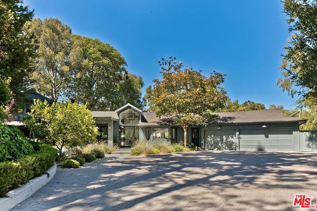 Tucked away behind a long gated drive, this beautifully renovated and fully furnished estate, designed by Gus Duffy Architect, offers the ultimate in privacy, comfort, and style in the heart of Fryman Canyon. Featuring 5 spacious bedrooms and 4.5 baths, the home blends sophisticated design with relaxed California living. The light-filled, open-concept living room boasts soaring wood-beamed ceilings, a dramatic fireplace, a custom bar, and a wall of disappearing glass doors that seamlessly connect to the stunning backyard. A formal dining room with a charming bay window sets the stage for elegant gatherings. The chef's kitchen features marble countertops, a center island, and premium appliances. The family/media room includes a fireplace, custom built-ins, and a well-placed office alcove. The serene primary suite offers a huge walk-in closet and a spa-like bathroom with a steam shower. Just outside, a private oasis includes a sauna, outdoor shower, and hot tub, creating your own personal wellness retreat. The lush backyard is complete with a sparkling pool and spa, outdoor kitchen, fire pit, and thriving vegetable garden, all surrounded by the natural beauty of Fryman Canyon. This home truly has it all.