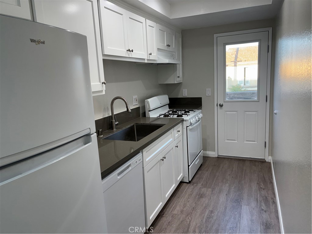 Recently Remodeled & Move-In Ready! Step into this beautifully updated second-floor end unit featuring a brand-new kitchen with sleek quartz countertops, a gas range, dishwasher, and a new refrigerator. Enjoy modern living with new laminate flooring throughout, recessed lighting, dual-pane windows, and fresh paint. Relax on your private balcony, and enjoy the added privacy of only one shared wall—with no neighbors above. Parking is a breeze with one detached garage space plus an additional assigned spot. Located in a low-density building with just six units, you'll also have access to convenient on-site community laundry. Prime location—just minutes from the beach, wetlands, Huntington Harbour, shopping, dining, and grocery stores. Rent includes: trash, water, and sewer.