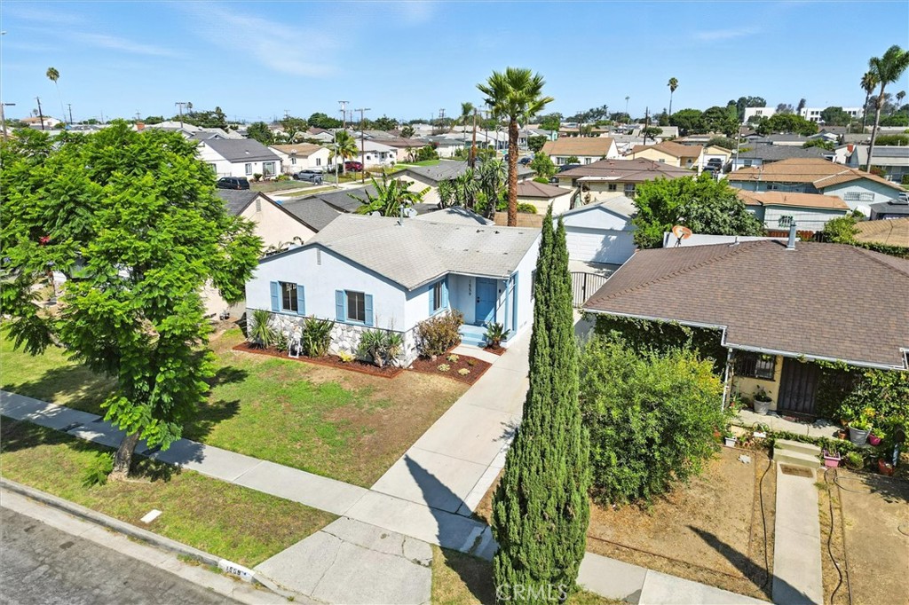Turnkey and move-in ready, this upgraded Los Angeles residence offers three bedrooms and two baths with the flexibility of a rare fourth primary suite option. A welcoming front lawn and covered porch set the tone, while a long gated driveway leads to a detached two-car garage. The private backyard invites relaxation, barbecues, and gatherings. Inside, a versatile family room with vaulted ceilings and backyard views can be converted into an additional primary suite with its own ensuite-style bath. Throughout the home, beautifully restored original hardwood floors add warmth and character, complemented by interior laundry and a kitchen updated with quartz countertops and a contemporary backsplash. Both bathrooms feature designer finishes — from a herringbone tile surround with brass accents to a sleek vertical stacked tile shower with matte black fixtures. Ideally located minutes from Chester Washington Golf Course, schools, shopping, and dining, with quick access to the 105 freeway and major venues including SoFi Stadium, Intuit Dome, and the Kia Forum. Classic charm, modern upgrades, and flexible living options come together in this distinctive property.