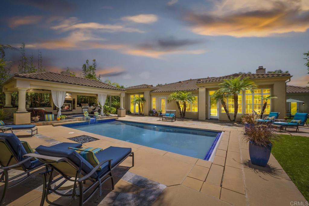 Single Story Aviara Pool Oasis! Located within the private gates of the highly sought after Bella Lago community in Coastal Aviara, this stunning estate home offers a luxurious lifestyle on one of the largest 1/3 acre corner lots in the neighborhood. Steps from the finest beaches in San Diego, this elegant home is situated on a peaceful cul de sac and is truly one of a kind as one of the only single story homes with an expansive additional bonus room! The resort-style backyard is an entertainer's dream featuring a sparkling pool and lush tropical landscaping with over 20 palm trees throughout the property. Relax in your hot tub by the cozy outdoor fireplace with mounted flat screen or entertain guests in the large outdoor pavilion complete with custom lighting, ceiling fans, built-in BBQ with gas stove and ice cooler. The incredible backyard oasis includes an in-ground water feature, garden, grass area, and 20-foot privacy walls for ultimate seclusion. This home perfectly blends indoor-outdoor living with seamless access to your private resort-style paradise. As you enter the flowing floor plan, you cannot miss the exquisite craftsmanship and custom finishes throughout this spacious home flooded with natural light. Large windows, beautiful stained ceiling beams, crown molding, and plantation shutters create a coastal luxurious feel while travertine and wood flooring, custom built-ins, soaring high ceilings, and the finest finishes complete each room. The spacious front yard with tropical landscaping leads you into a home where tranquility and function are blended together perfectly. The chef's kitchen showcases a new striking stainless steel built-in refrigerator, double Bosch ovens, large undermount sink, breakfast nook, desk area, and butler's pantry with wine fridge. A wall of windows in the family room features a large seating bench great for entertaining while overlooking the garden area and backyard paradise. Retreat to the luxurious master suite with spacious lounge area featuring a fireplace - perfect for use as a workout space, art studio, or sitting area. The master spa highlights dual granite vanity with custom countertop sinks, Jacuzzi tub, walk-in glass shower with ceiling rainfall head, steam shower, walk-in closet, and door leading directly to the backyard oasis. The bonus room features a custom designed 300-bottle wine cellar and built-in bar with granite countertop, plus its own granite bathroom. This versatile space opens onto a manicured private garden and can easily serve as an additional bedroom, guest quarters, office, or game room. Additional highlights include tankless water heater, surround sound, recessed lighting, epoxy garage, newer windows, large front lawn, 3-car garage, electronic pool cover, ceiling fans, ample storage, laundry room, and DCS outdoor BBQ. You will love this extraordinary home in a perfect location! Steps away from Batiquitos lagoon this sought-after coastal community is surrounded by greenbelts and strolling paths along the water with easy access to everything that makes North County amazing. Spend your weekends exploring the lagoon, teeing off at Aviara Golf Club, or catching golden hour at the Park Hyatt or Omni La Costa. Top-rated Aviara Oaks Elementary and Middle Schools just minutes away! This home offers an unrivaled living experience blending elegance and comfort in the heart of Aviara! A tranquil enclave close to shopping, world-class golf courses and restaurants.