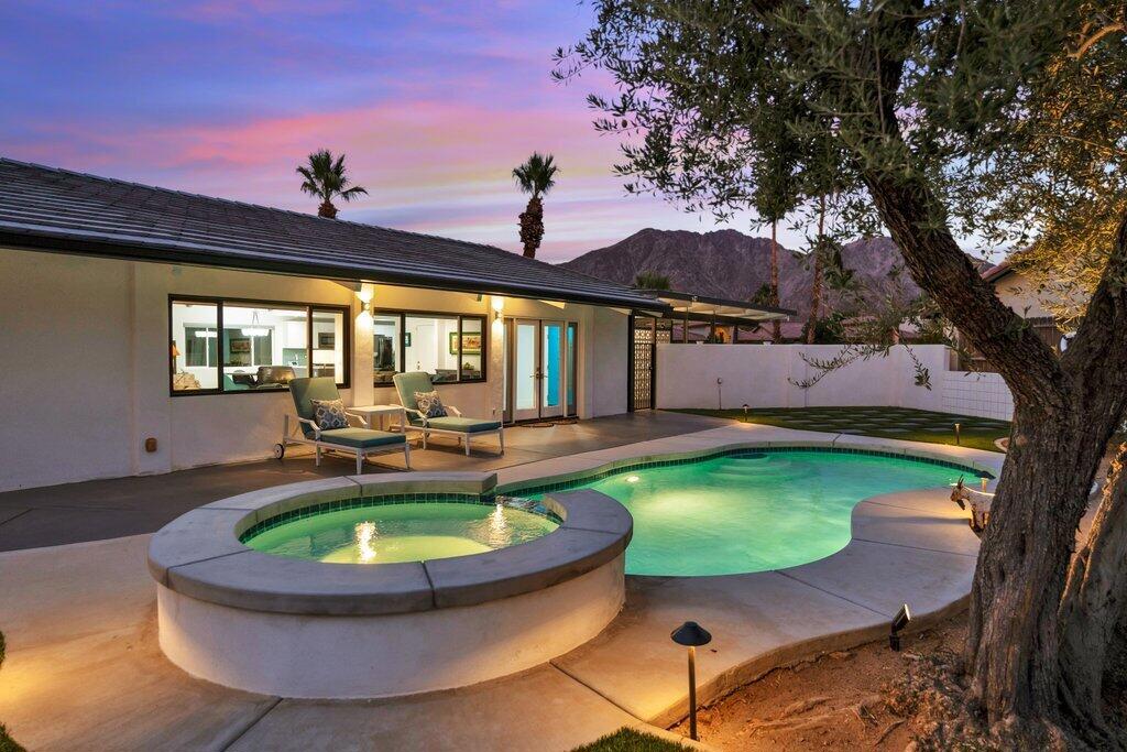 You can now own this stunning Late Mid-Century Modern home, beautifully positioned on a rare corner double lot in the highly sought-after La Quinta Cove. Thoughtfully redesigned by a former Walt Disney Imagineer, this residence is loaded with over $150,000 in upgrades and blends classic architecture with refined 21st-century style. Originally built in 1970, the home retains its vintage charm while embracing modern convenience and design. Step inside to find tongue-and-groove cathedral ceilings, exposed dark wood beams, and gorgeous tile floors that flow throughout. The original rock fireplace, preserved as a dramatic centerpiece, adds both texture and character to the open concept living space. The layout is ideal for entertaining, with the kitchen, dining, and living areas seamlessly connected--perfect for hosting everything from cozy dinners to lively weekend gatherings. The kitchen has been updated with a contemporary touch, designed to be both functional and stylish, while allowing the home's architectural integrity to shine through. Every detail--from lighting to finishes--has been carefully curated to create a harmonious blend of form and function. Outside, the oversized 9,583 sq ft lot has been transformed into a private resort-style escape. A sparkling pool and spa take center stage, framed by a classic Mid-Century Modern masonry privacy wall and surrounded by easy-care desert landscaping. Outdoor lighting sets the mood after sunset, creating the perfect ambiance for relaxing under the desert stars. Whether lounging poolside or dining al fresco, this backyard was made for year-round enjoyment. Located just a short drive from the world-famous Empire Polo Grounds--home of the Coachella and Stagecoach music festivals--and the Indian Wells Tennis Garden, this home also offers effortless access to scenic hiking and biking trails, championship golf courses, and the best of La Quinta's vibrant restaurant and boutique shopping scene. Whether you're looking for a stylish full-time residence, a designer-inspired vacation home, or a unique investment opportunity, this one-of-a-kind Mid-Century gem delivers timeless style, modern upgrades, and a location that defines the desert lifestyle. The furnishings are available outside of escrow excluding the artwork.