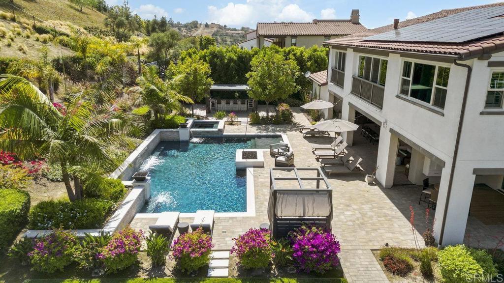 This immaculate, turnkey estate includes a coveted Legacy Golf (extended family) Membership at The Crosby Club at Rancho Santa Fe. Welcome to the pinnacle of luxury living in one of San Diego’s most exclusive enclaves! Located within the prestigious, guard-gated community of The Lakes Above Rancho Santa Fe, this spectacular Sterling Heights Plan 3 estate makes its debut on the market. Just 5 years new, this exceptional residence is situated on a generous 1-acre lot adorned with lush landscaping and resort-style amenities, creating a serene and private retreat. Offering over 5,500 square feet of refined living space, this architectural gem features 5 spacious bedrooms, 5.5 luxurious bathrooms, and a 4-car garage. From the moment you enter, you’re greeted by soaring 22-foot ceilings that create a dramatic, open feel. Expansive oversized windows and a full wall of retractable glass doors bathe the interiors in natural light, highlighting the rich hardwood flooring that runs throughout the home. Designed for elevated everyday living and effortless entertaining, the open-concept layout includes a formal dining room and a chef’s kitchen outfitted with a sleek contemporary backsplash and premium finishes. On the main level, you’ll find a spacious guest suite with a private en suite bath, as well as a flexible bonus room—ideal for a home office, gym, or game room. Upstairs, the primary suite is a private sanctuary overlooking the stunning backyard and pool. The spa-inspired primary bath features dual vanities, an oversized soaking tub, and a massive walk-in shower, complemented by a custom walk-in closet. Three additional upstairs bedrooms each offer en suite baths and built-in custom closets, while a large loft area provides additional space for a media room, lounge, or playroom. The expansive laundry room adds even more convenience, offering ample built-in cabinetry and storage. Step outside to your resort-worthy backyard oasis, where a modern pool and spa, fully equipped outdoor kitchen, sports court, and space for a grassy play area or garden await. Whether hosting guests or enjoying a quiet afternoon in the sun, this backyard is designed for unforgettable moments! Additional highlights include solar, a whole house water filtration system, a 4-car garage, and generous driveway parking. Residents can enjoy world-class amenities, including golf, dining, entertainment, fitness center, tennis, pickleball, and a heated lap pool. Located within the award-winning Poway Unified School District, with top-rated schools like Del Norte High, The Lakes offers a family-friendly community and an unbeatable Southern California lifestyle. With 25 golf courses, 17 parks, and 4 hiking reserves within 10 miles, and over 79 restaurants within 5 miles, there's no shortage of activities to enjoy. Conveniently located minutes from I-15 and CA-56 freeways, this exceptional property offers unparalleled access to all that San Diego has to offer. Don’t miss your chance to own this stunning Sterling Heights estate and live the ultimate California dream.