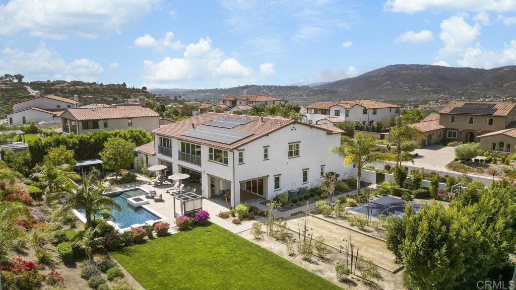 This immaculate, turnkey estate includes a coveted Legacy Golf (extended family) Membership at The Crosby Club at Rancho Santa Fe. Welcome to the pinnacle of luxury living in one of San Diego’s most exclusive enclaves! Located within the prestigious, guard-gated community of The Lakes Above Rancho Santa Fe, this spectacular Sterling Heights Plan 3 estate makes its debut on the market. Just 5 years new, this exceptional residence is situated on a generous 1-acre lot adorned with lush landscaping and resort-style amenities, creating a serene and private retreat. Offering over 5,500 square feet of refined living space, this architectural gem features 5 spacious bedrooms, 5.5 luxurious bathrooms, and a 4-car garage. From the moment you enter, you’re greeted by soaring 22-foot ceilings that create a dramatic, open feel. Expansive oversized windows and a full wall of retractable glass doors bathe the interiors in natural light, highlighting the rich hardwood flooring that runs throughout the home. Designed for elevated everyday living and effortless entertaining, the open-concept layout includes a formal dining room and a chef’s kitchen outfitted with a sleek contemporary backsplash and premium finishes. On the main level, you’ll find a spacious guest suite with a private en suite bath, as well as a flexible bonus room—ideal for a home office, gym, or game room. Upstairs, the primary suite is a private sanctuary overlooking the stunning backyard and pool. The spa-inspired primary bath features dual vanities, an oversized soaking tub, and a massive walk-in shower, complemented by a custom walk-in closet. Three additional upstairs bedrooms each offer en suite baths and built-in custom closets, while a large loft area provides additional space for a media room, lounge, or playroom. The expansive laundry room adds even more convenience, offering ample built-in cabinetry and storage. Step outside to your resort-worthy backyard oasis, where a modern pool and spa, fully equipped outdoor kitchen, sports court, and space for a grassy play area or garden await. Whether hosting guests or enjoying a quiet afternoon in the sun, this backyard is designed for unforgettable moments! Additional highlights include solar, a whole house water filtration system, a 4-car garage, and generous driveway parking. Residents can enjoy world-class amenities, including golf, dining, entertainment, fitness center, tennis, pickleball, and a heated lap pool. Located within the award-winning Poway Unified School District, with top-rated schools like Del Norte High, The Lakes offers a family-friendly community and an unbeatable Southern California lifestyle. With 25 golf courses, 17 parks, and 4 hiking reserves within 10 miles, and over 79 restaurants within 5 miles, there's no shortage of activities to enjoy. Conveniently located minutes from I-15 and CA-56 freeways, this exceptional property offers unparalleled access to all that San Diego has to offer. Don’t miss your chance to own this stunning Sterling Heights estate and live the ultimate California dream.