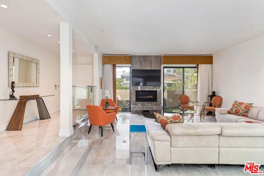 Exquisite, sleek, and sun-filled, this contemporary two-bedroom townhome offers sophisticated living in the heart of Century City's coveted Century Hill - a prestigious, guard-gated enclave set on 18 acres of lush, landscaped grounds. This immaculate three-level residence welcomes you through a private huge, gated patio on its courtyard level into a voluminous living room with soaring ceilings, a striking marble fireplace, and a dramatic central atrium that floods the space with natural light. The open-concept layout flows effortlessly into a formal dining area and adjacent open-air atrium, perfect for al fresco dining or relaxed entertaining. The modern kitchen is thoughtfully designed with stainless steel appliances, ample cabinetry, and a cheerful breakfast area complemented by a chic powder room and sleek wet bar on the main floor. Upstairs, beneath a large skylight, the grand primary suite offers a tranquil retreat with a cozy fireplace, sitting area, and private balcony showcasing sweeping hillside views. The spa-inspired bath features dual vanities, a soaking tub, separate shower, private water closet, and large walk-in closet. A spacious guest suite with full bath and open den area completes the upper level. On the lower, subterranean level, enjoy direct private access from a two-car garage, a dedicated laundry room, and additional large storage room space (can be converted back to 3rd parking space) enhancing the convenience and livability of this refined home. Century Hill's resort-style amenities include five sparkling pools, tennis and pickleball courts, an indoor racquetball court, golf driving range, state-of-the-art fitness center, manicured walking paths, and a stunning clubhouse with full catering kitchen all secured by 24/7 guarded access and enhanced by attentive resident services, including day-to-evening package delivery. Ideally located moments from world-class dining, shopping, and entertainment in Century City, Beverly Hills, and Westwood, this exceptional townhome is a rare expression of modern luxury and timeless design.