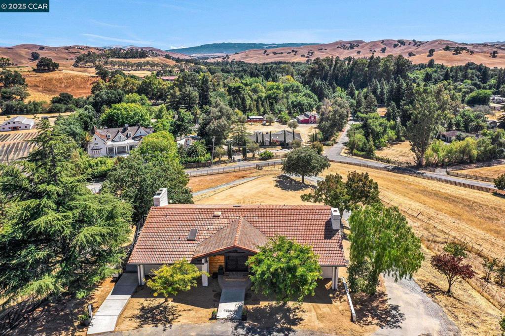 Discover your own private retreat in this stunning updated hilltop rancher on 2.16 acres with panoramic hill views, elegant hardwood floors, and a chef’s kitchen designed for entertaining. This home offers open, airy living at its finest an open-concept layout, and high-end finishes. The chef’s kitchen boasts dual islands, waterfall quartz countertops, built-in appliances, coffee and wine bars, and opens to a spacious family room with electric fireplace all with views and sliding glass door to deck. The luxurious primary suite offers a walk-in closet, fireplace, private deck, and a separate spa-like bath with soaking tub and glass-enclosed shower and another private deck - take a cold plug in privacy! Outdoor living includes multiple decks, flat usable areas for a pool or arena, and a large shed. Bonus: ADU- 3 bed/1 bath. Private gated entry, new fencing, riding area, Mt Diablo access — just 10 minutes to shopping! Country living at it's finest! Video link: https://youtu.be/EH4-gGo_aRU Open Thursday 11:30-2pm & Sunday 1-4pm