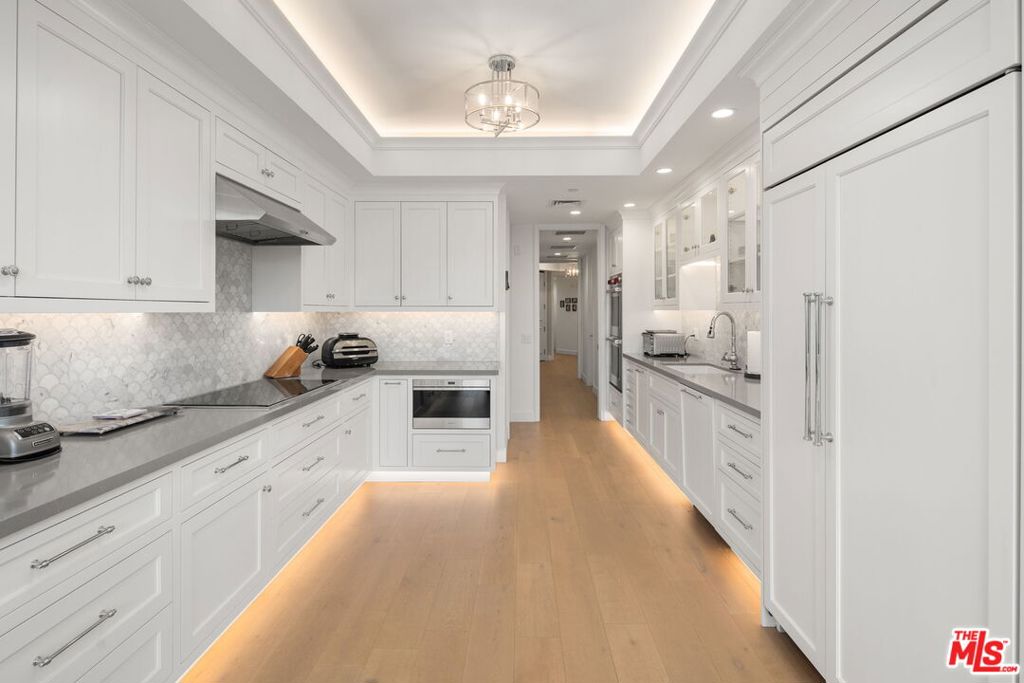 Welcome to arguably the most stunning unit in the iconic IV Seasons Condominiums, where residents enjoy not only the utmost in safety, amenities, and security with 24/7 doormen, valet parking, pool/gym/spa, but also Beverly Hills famed services  police and fire departments as well as schools. Situated on the third floor with a lovely, sunny view of the quiet, tree-lined street, Unit 354 was meticulously renovated in 2022, producing a completely turn-key experience. This 2-bedroom plus den/office/media room within proximity to the best restaurants in BH as well as Whole Foods, Erewhon, and designer shops on Rodeo Drive features wide-plank wood floors and a light-filled entryway, setting the stage for a grand living room with a high ceiling, exposed beams, a fireplace and sliding doors to the tranquil patio. Designed for entertaining, the dining room features a table for eight, leading into the sun-flooded eat-in kitchen with all-new Wolf and Fisher & Paykel appliances. Down the hall is the ample laundry room and elegant powder room. The den/office can double as an extra bedroom, and the true second bedroom and ensuite bath are equally sun-filled. Occupying its own space at the end of a long hallway, lined with closets as well as a separate walk-in space, is the primary bedroom, a sanctuary of its own. Its ensuite spa bath is the ultimate in luxury, featuring a double set of sinks, a built-in dressing table, a freestanding soaking tub and an enormous shower. Boasting the building's most spacious layout, this elegant property is not to be missed.