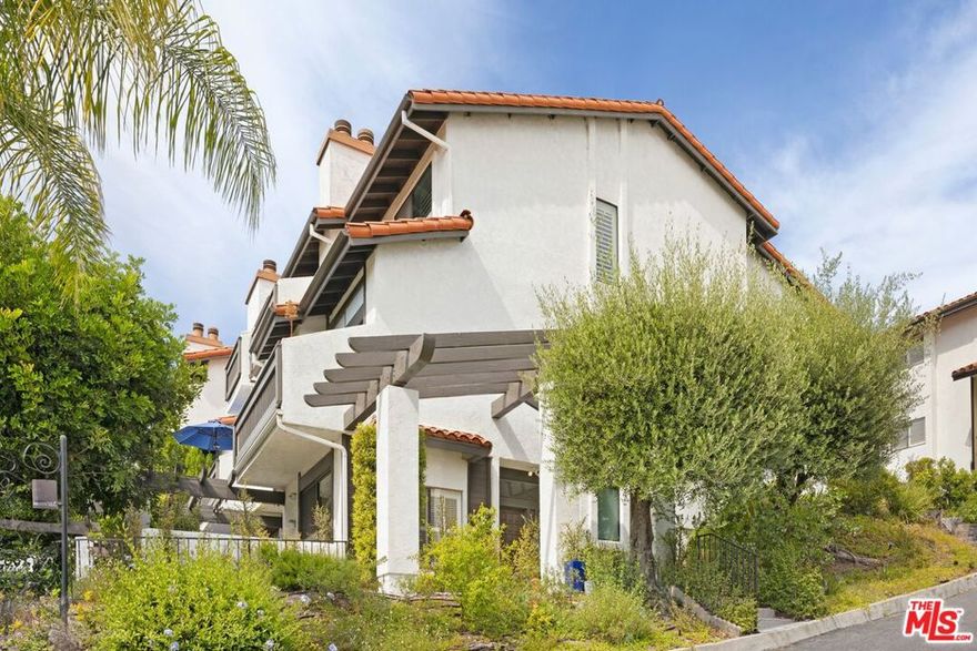 Experience luxurious living in this beautifully remodeled end-unit townhouse located in the highly sought-after Michael Lane Villas in Pacific Palisades. This spacious Highlands home offers 3 bedrooms and 3.5 bathrooms, featuring one of the most desirable floor plans in the community. Step into a bright and airy living room with soaring ceilings, recessed lighting, elegant wood floors, a cozy fireplace, and a balcony ideal for relaxing or entertaining guests. The formal dining room boasts scenic mountain views, while the kitchen includes a charming breakfast area, updated appliances including double ovens and a warming drawer. There is direct access to the main level of the home (with powder room) from the attached two-car garage in addition to the lower level front entry, for added convenience. Upstairs, the expansive primary suite offers stunning mountain views, a comfortable sitting area, and double closets - including a walk-in. The en-suite bathroom includes dual vanities and a separate shower. A secondary upstairs bedroom features its own private bathroom and built-in desk, perfect for guests or a home office setup. The lower level includes a third bedroom and full bath, along with a family room and office area that opens to a large private patio. This versatile space can easily be used as a separate guest suite or multi-purpose living area. Additional highlights include a new washer and dryer and access to the community amenities, which include a pool, spa, and fitness center.